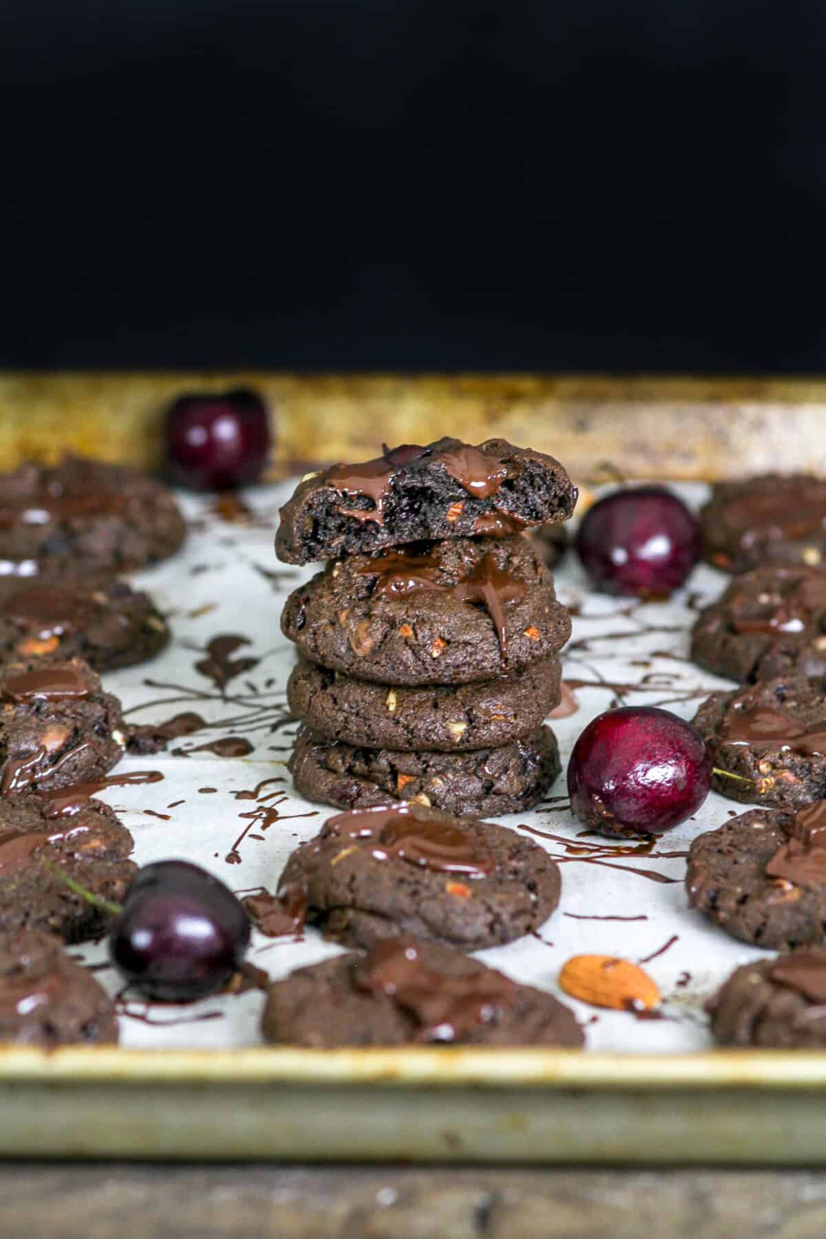 chocolate cherry almond cookies stacked on a tray