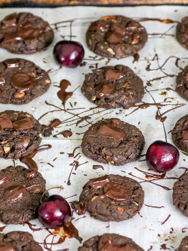 cookies on a tray with melted chocolate and cherries