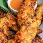 Spicy Coconut Chicken Tenders on a plate with black pepper hot sauce