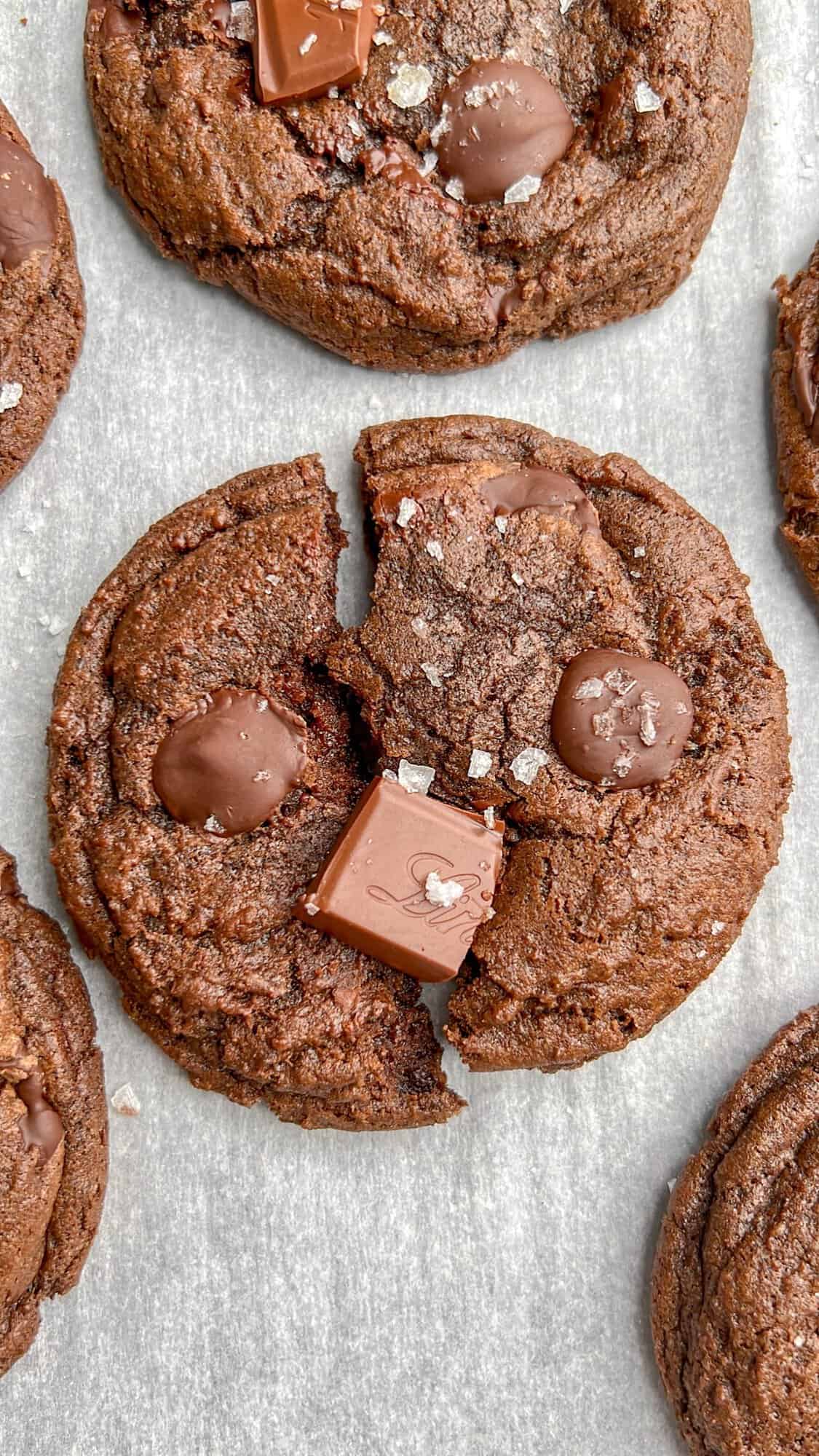 These Salted Double Chocolate Cookies are perfectly chewy and soft with a little crispness on the edges. Super easy to make! Overhead view of a salted double chocolate cookie on the counter