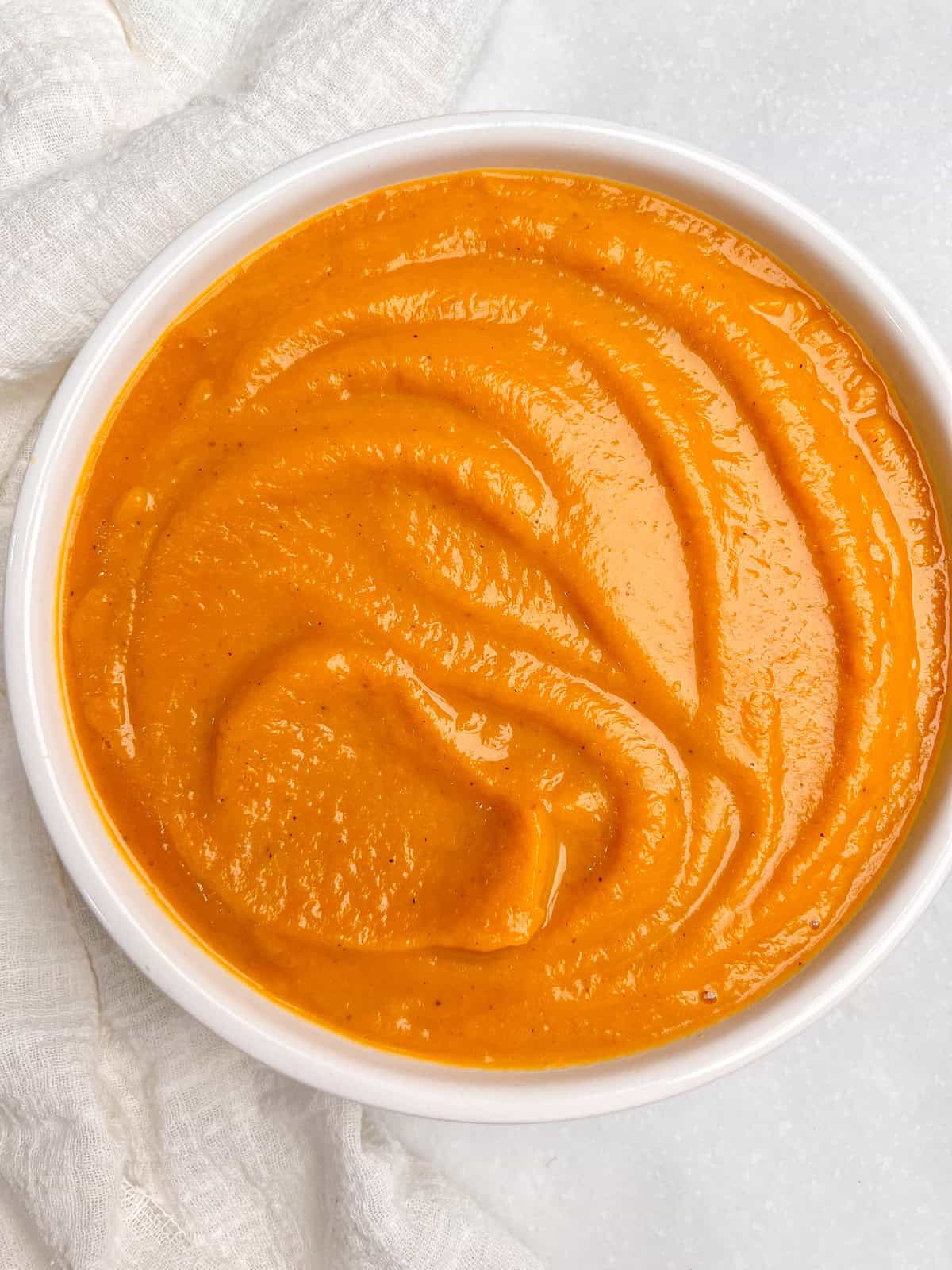 With rich, buttery flavor, warm spices, and a velvety smooth texture, this Copycat Panera Autumn Squash Soup tastes just like the restaurant! Overhead view of a bowl of Copycat Panera Autumn Squash Soup