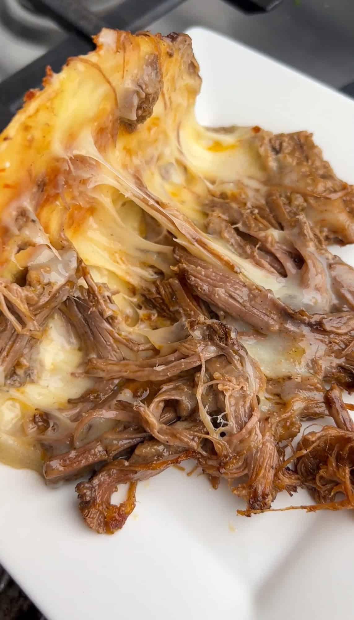 These Braised Brisket Tacos are pan-fried with melty cheese then topped with tangy street corn salad and creamy jalapeno lime ranch. A brisket taco with melted cheese opened to add toppings