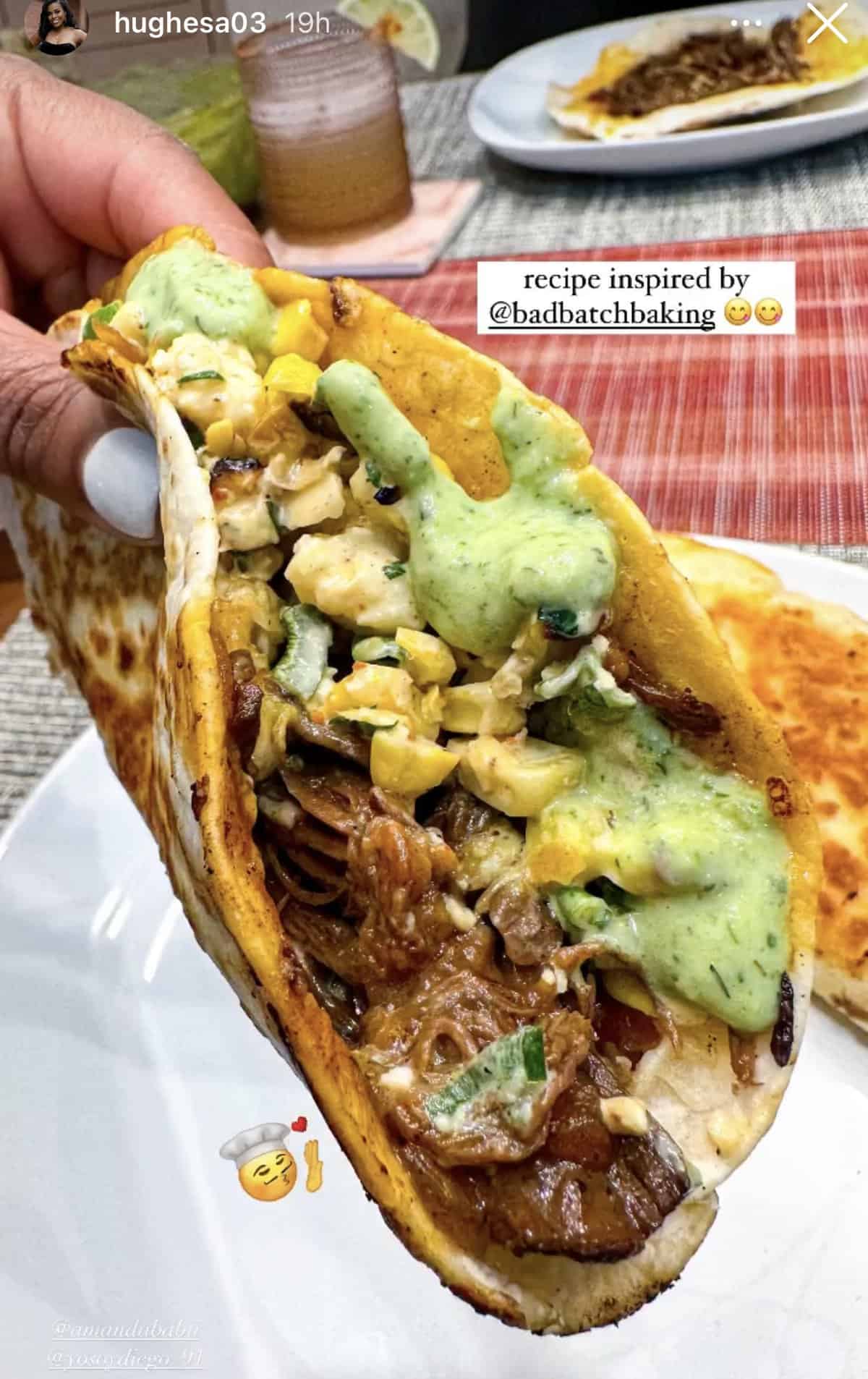 These Braised Brisket Tacos are pan-fried with melty cheese then topped with tangy street corn salad and creamy jalapeno lime ranch. A hand holding a basket taco