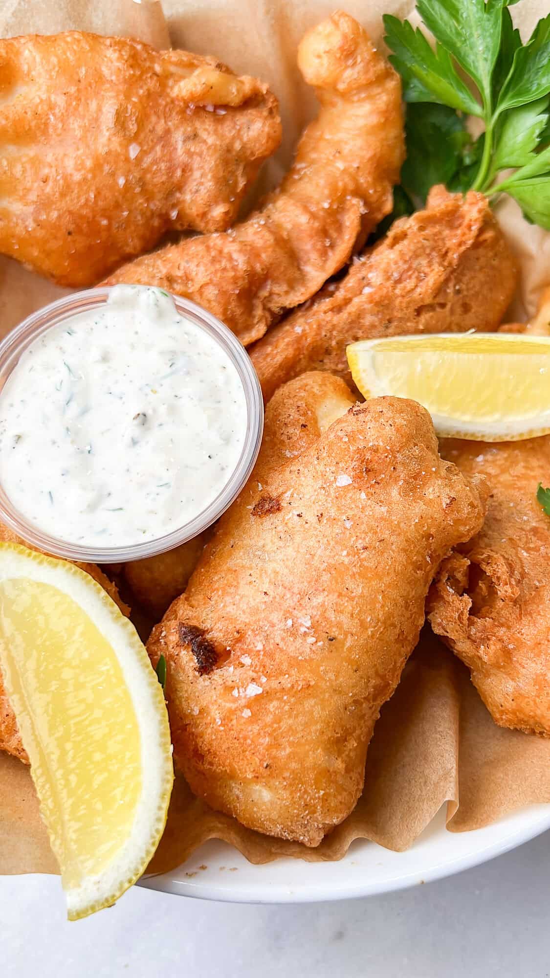 Halibut is coated in a beer batter that puffs up beautifully & is paired with crispy homemade fries to make the absolute BEST fish and chips. A plate of beer battered fish