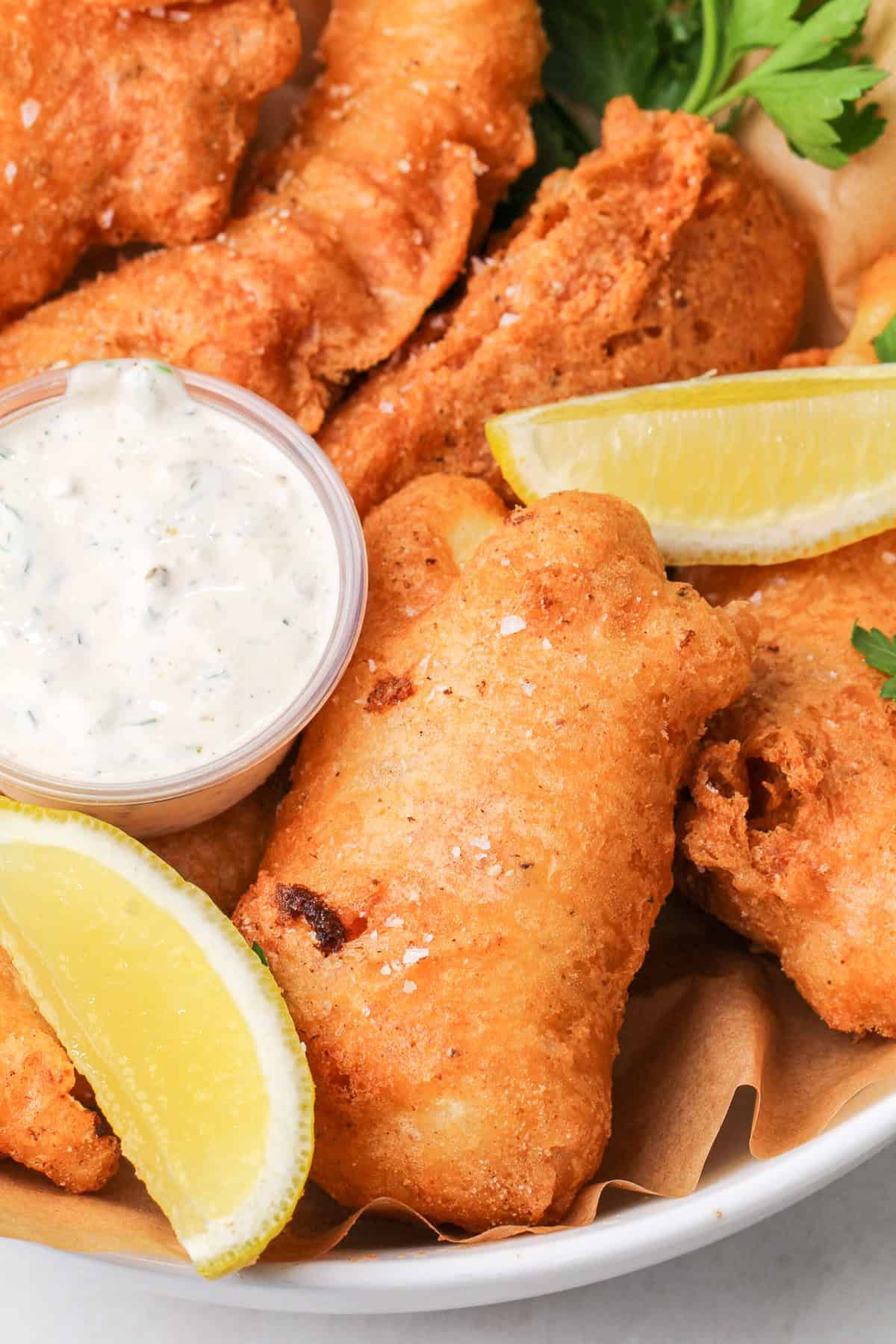 Halibut is coated in a beer batter that puffs up beautifully & is paired with crispy homemade fries to make the absolute BEST fish and chips. A plate of beer battered fish