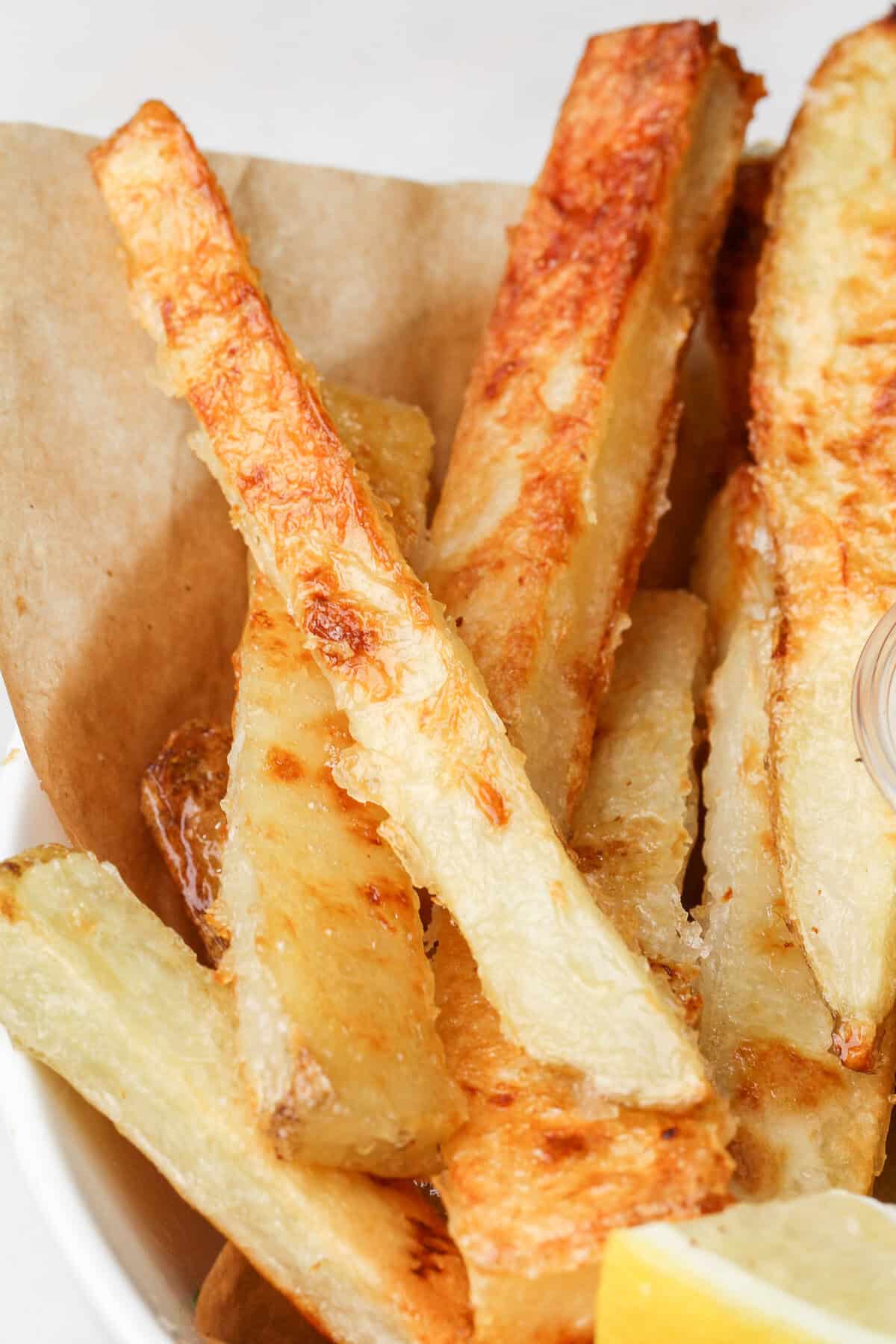 Halibut is coated in a beer batter that puffs up beautifully & is paired with crispy homemade fries to make the absolute BEST fish and chips. Close up of crispy homemade fries