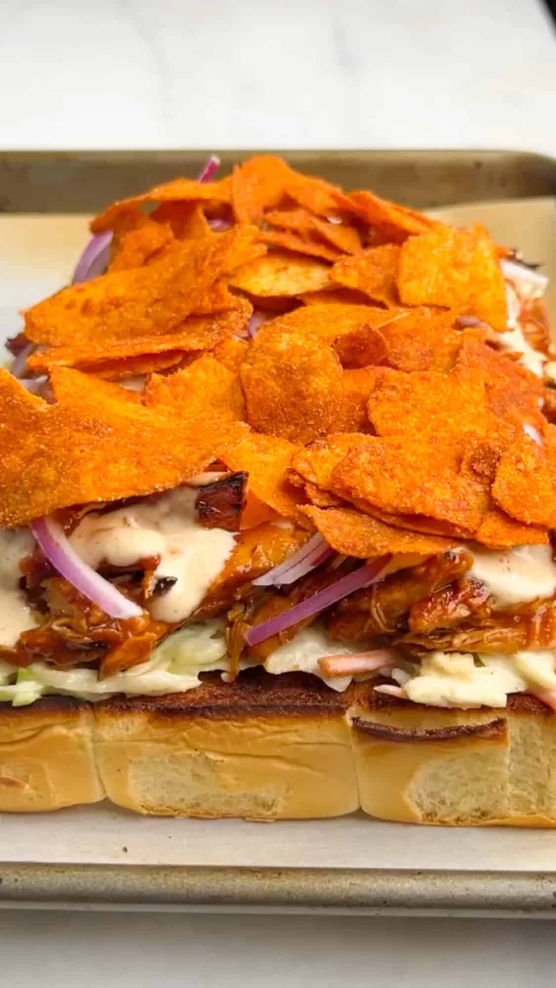 Shredded BBQ chicken, coleslaw tossed in Alabama white sauce, and crunchy chips make these BBQ Chicken Sliders unforgettable. BBQ potato chips layers on top of chicken on sliders