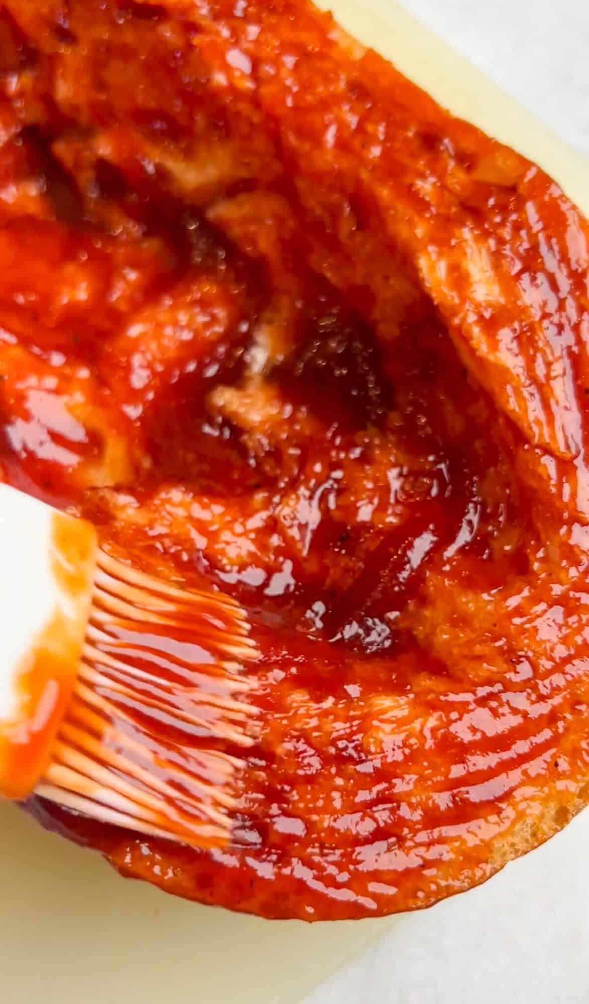 Crusty French bread is topped with sauce, cheese, and any toppings of choice, and then baked in this French Bread Pizza recipe. Spreading BBQ sauce on French bread