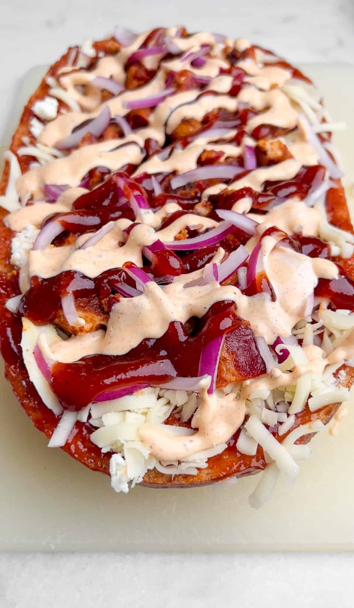 Crusty French bread is topped with sauce, cheese, and any toppings of choice, and then baked in this French Bread Pizza recipe. French bread topped with BBQ chicken, cheese, onions, and sauce