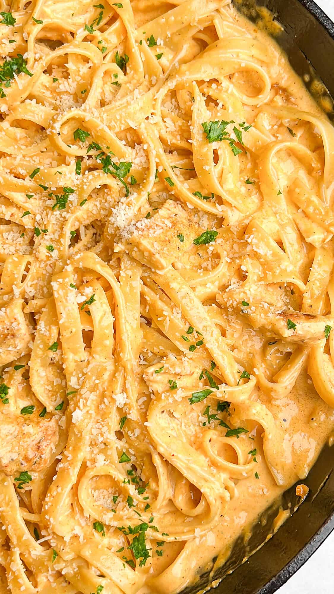 Overhead view of creamy buffalo chicken pasta in a large skillet.