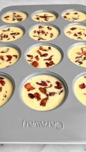 This copycat Starbucks egg bites recipe with bacon gruyere cheese has a soft custard-like texture & is made in the oven without a sous vide. Whisked eggs and bacon in muffin tins