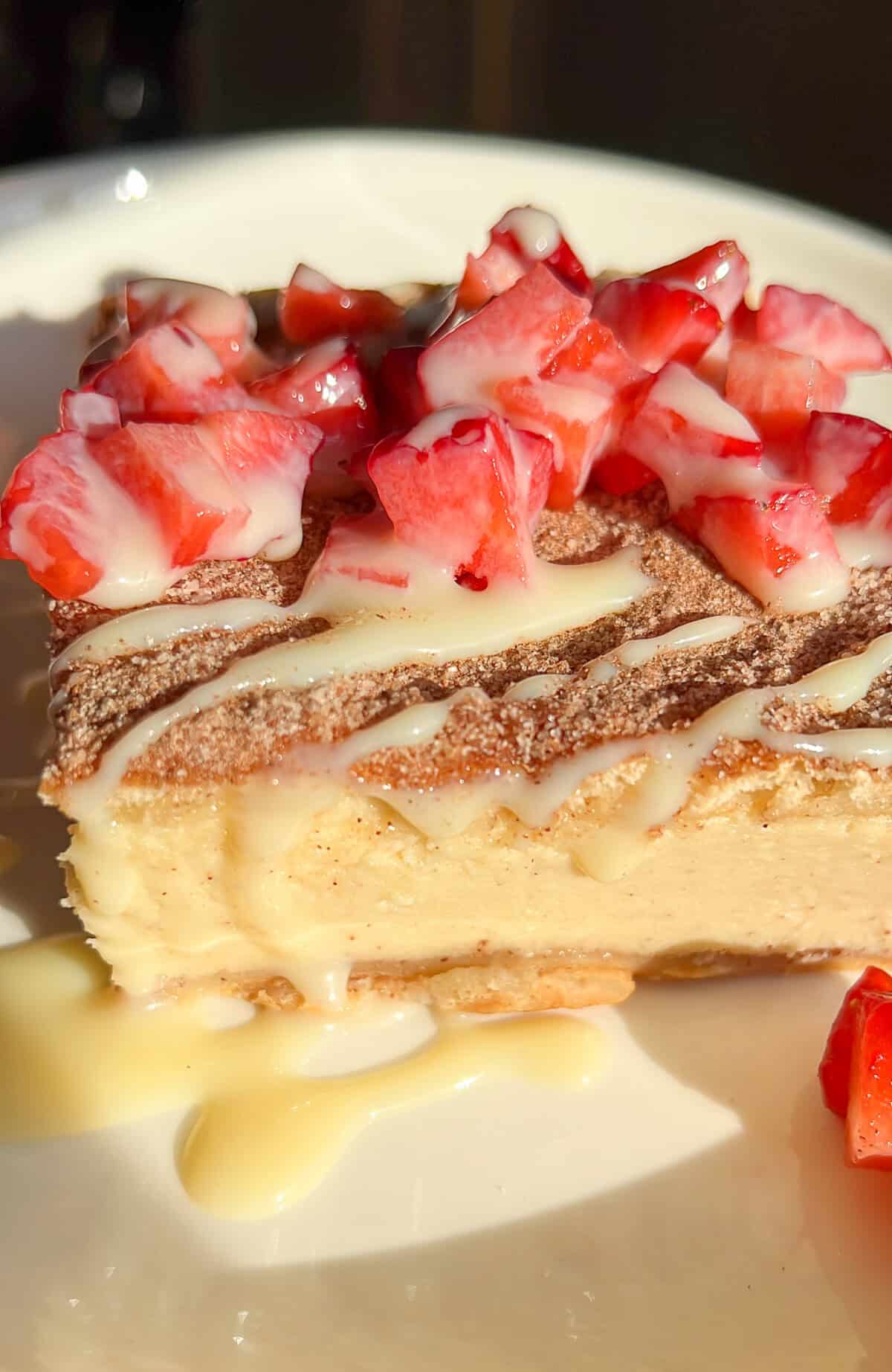 diced strawberries and sweetened condensed milk drizzled over churro cheesecake