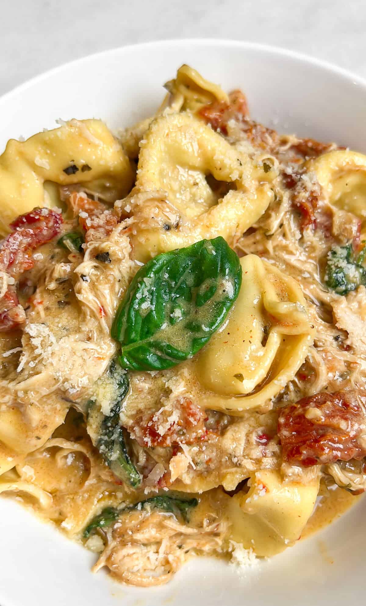 Marry me chicken tortellini is an easy slow cooker recipe, with tender chicken, tortellini, and basil in rich sun-dried tomato cream sauce. Marry me chicken tortellini in a bowl.