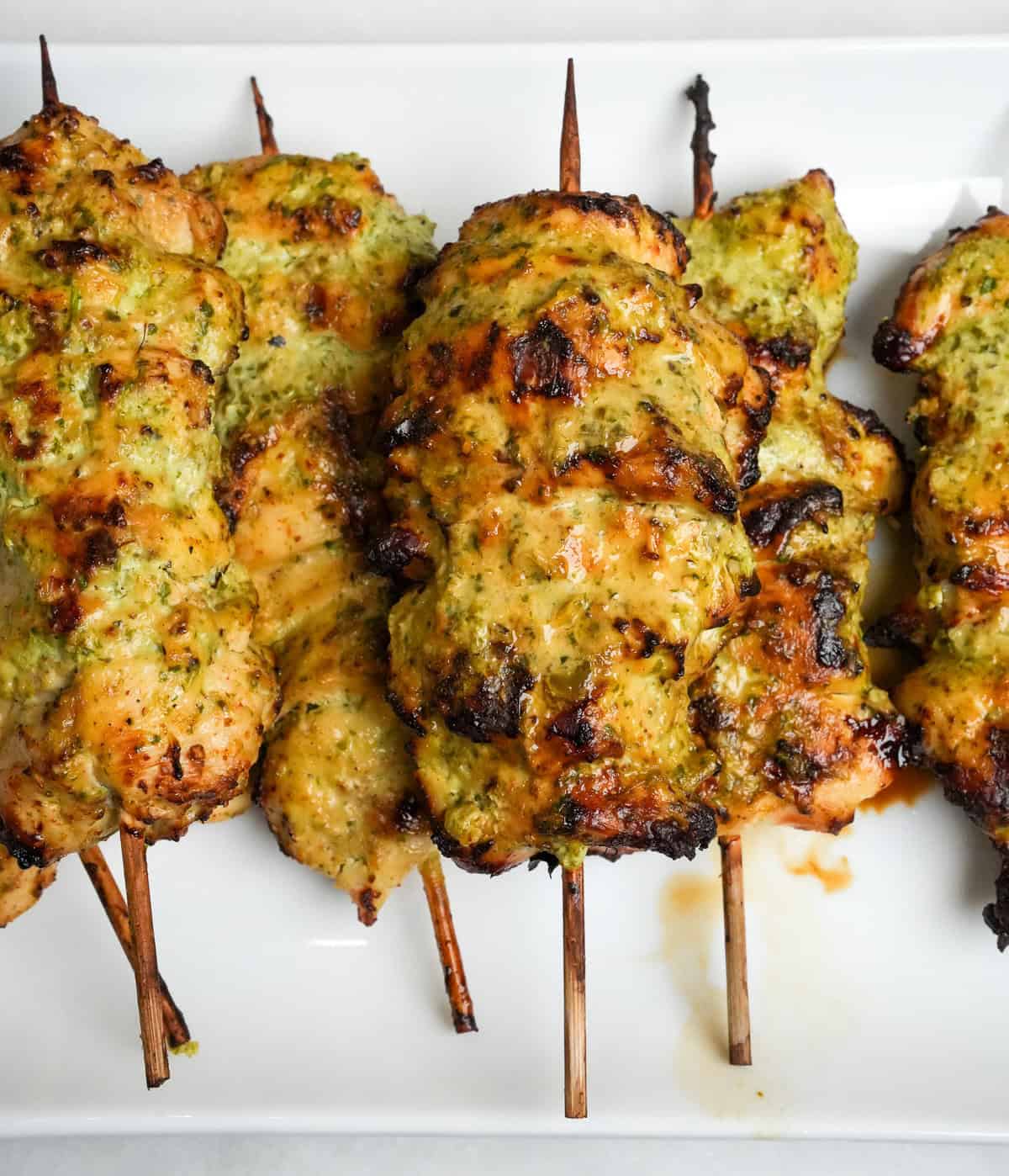 Full of fresh and vibrant flavors, these Cilantro Lime Air Fryer Chicken Skewers are tangy, herby, and so incredibly tender. Air fryer chicken skewers on a white plate
