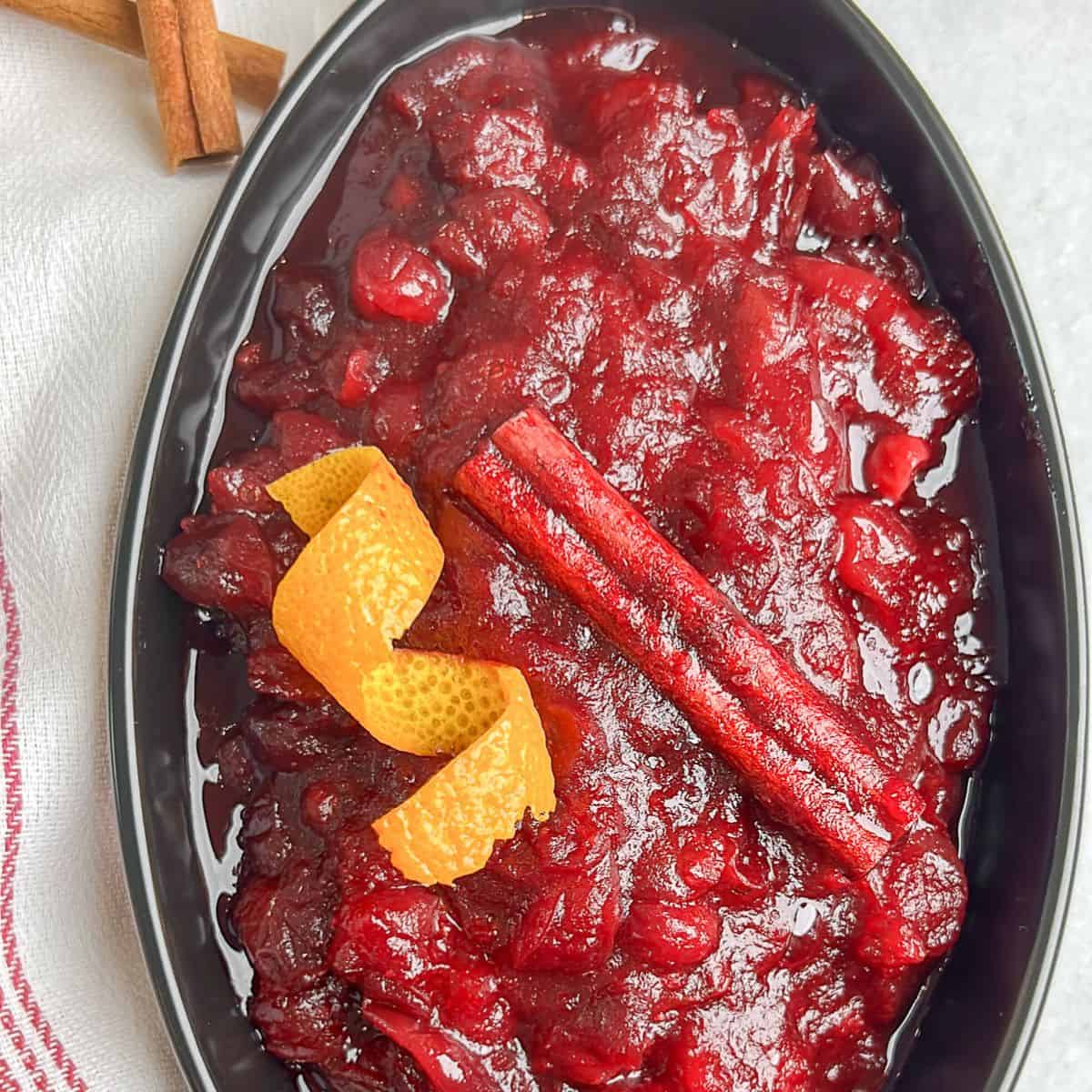 Skip the canned stuff this year. This 20-minute cranberry sauce is made from fresh cranberries, with a hint of orange and warming cinnamon. Overhead shot of cranberry sauce in a serving dish.