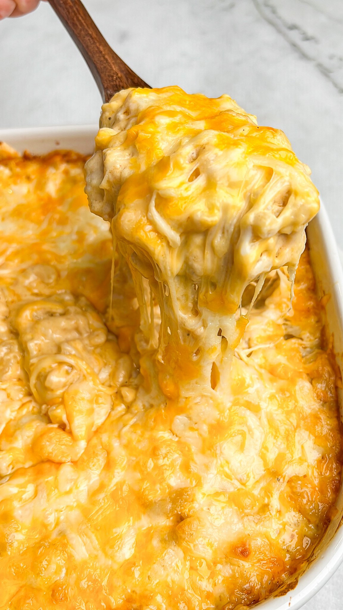 gooey cheese macaroni and cheese being lifted out of a pan