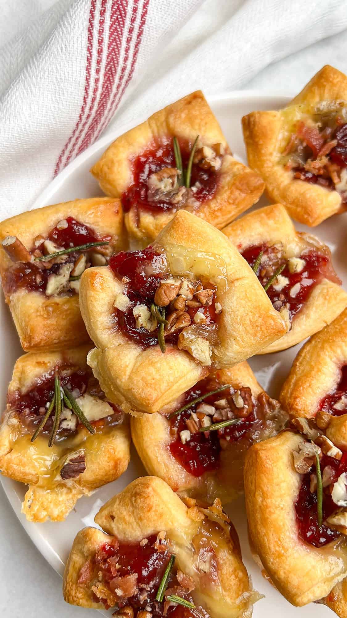 baked brie cranberry bites baked in puff pastry, freshly baked sitting on a plate