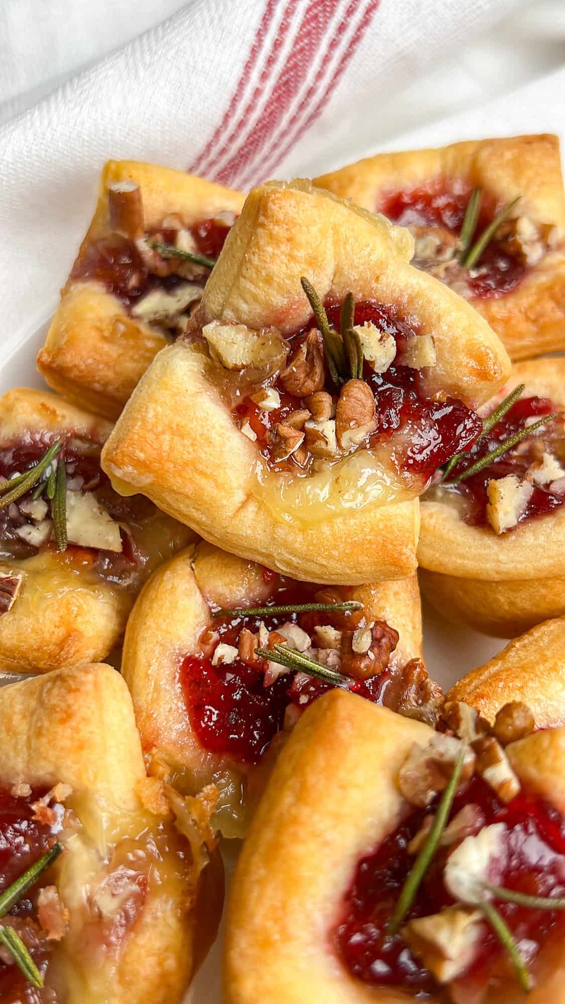 baked brie cranberry bites baked in puff pastry, stacked on a plate