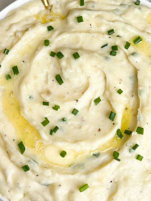 a bowl of whipped mashed potatoes with pats of butter