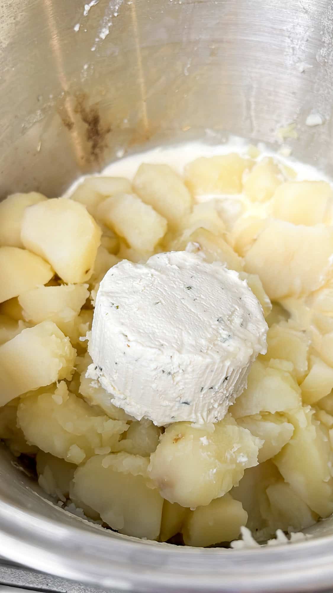 adding boursin cheese to the mashed potatoes