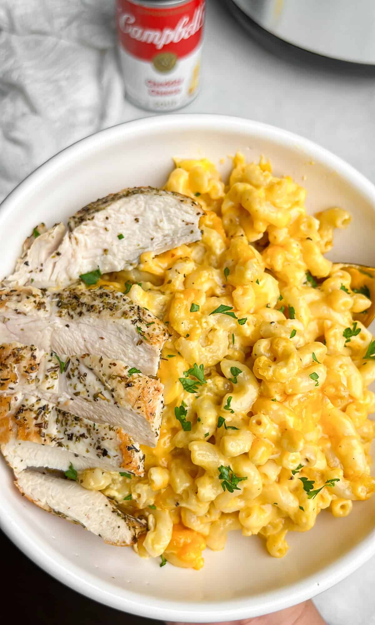 creamy cheese mac and cheese in a bowl with sliced chicken