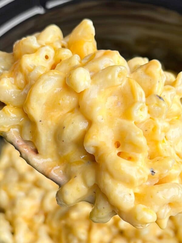 creamy mac and cheese in a slow cooker on a spoon