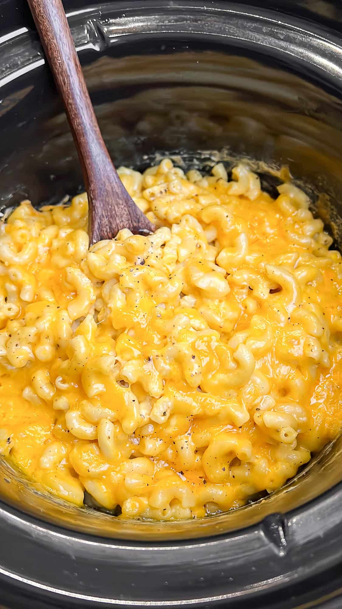 mac and cheese in a slow cooker with a spoon