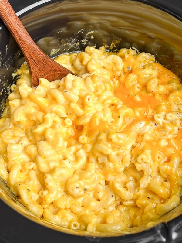 Featured image of slow cooker mac and cheese with a wooden spoon.