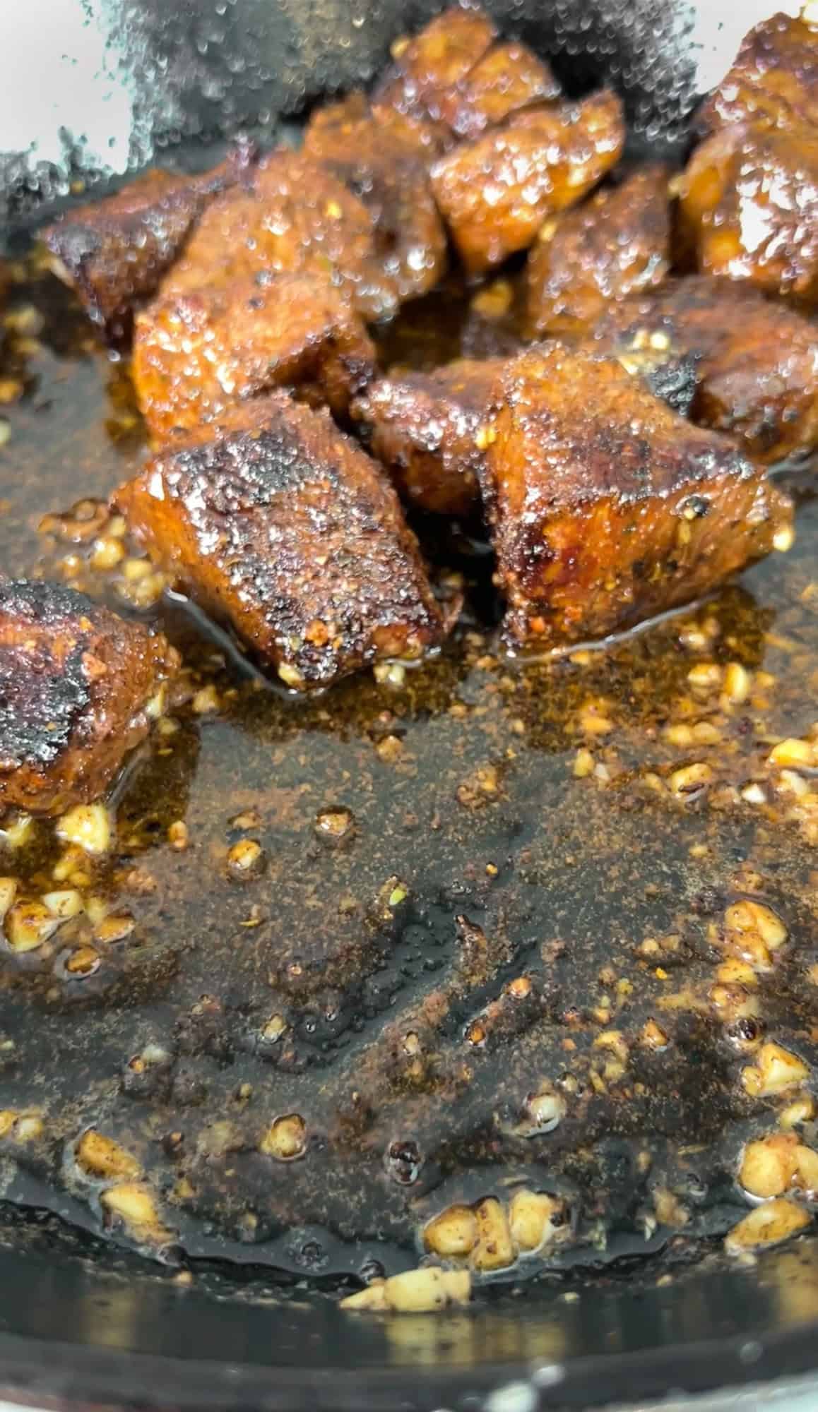 steak bites being tossed in butter and garlic