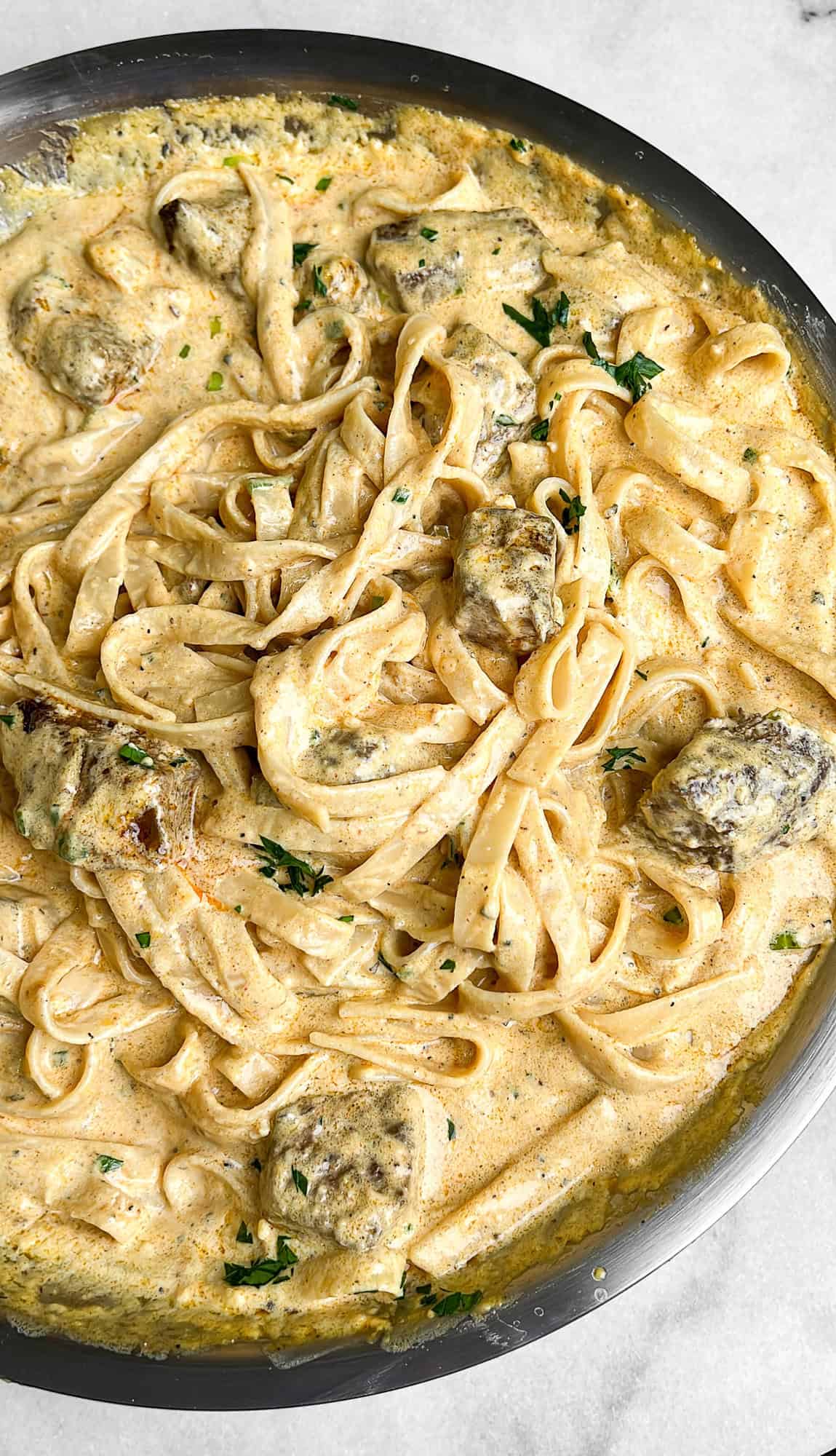 creamy steak fettuccini alfredo in a pan