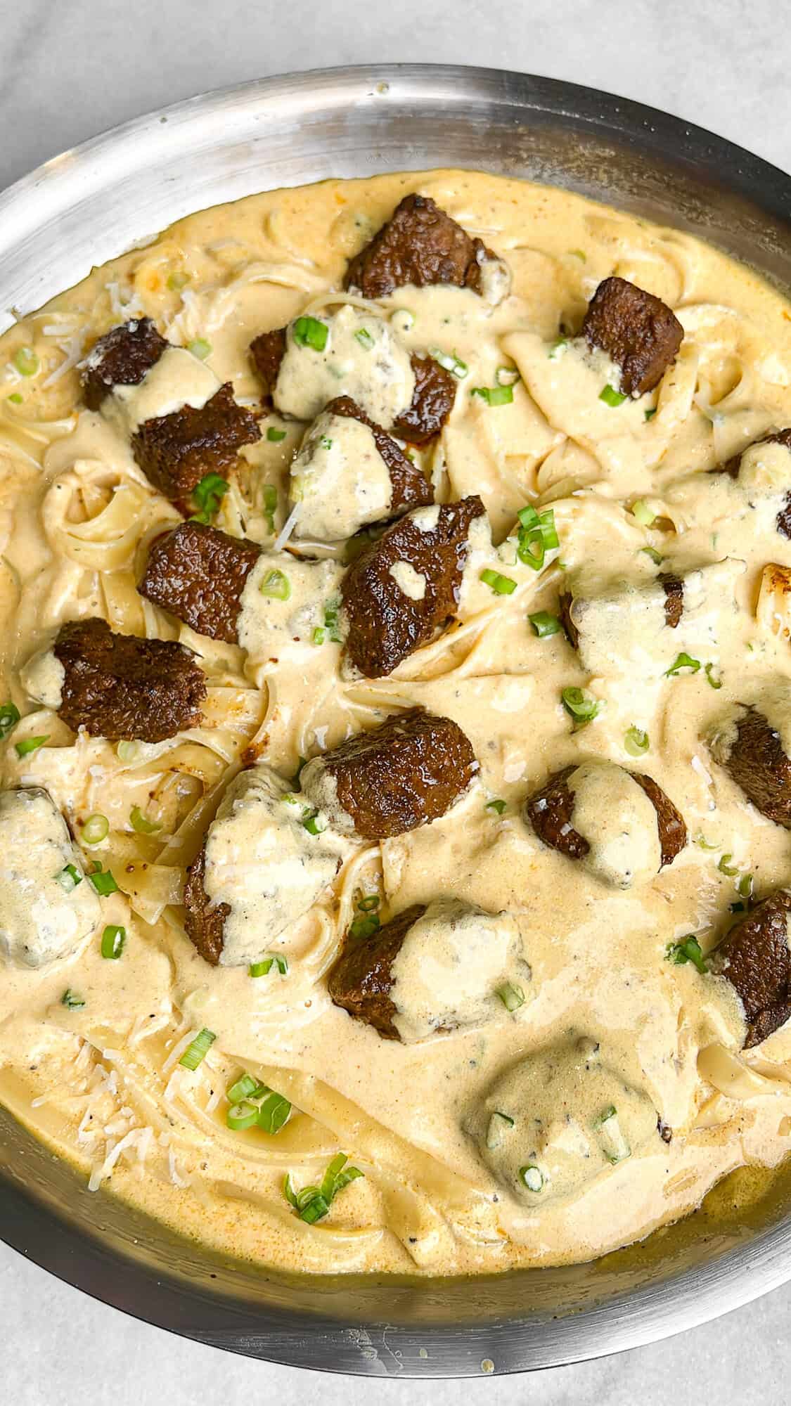 creamy steak fettuccini alfredo in a pan