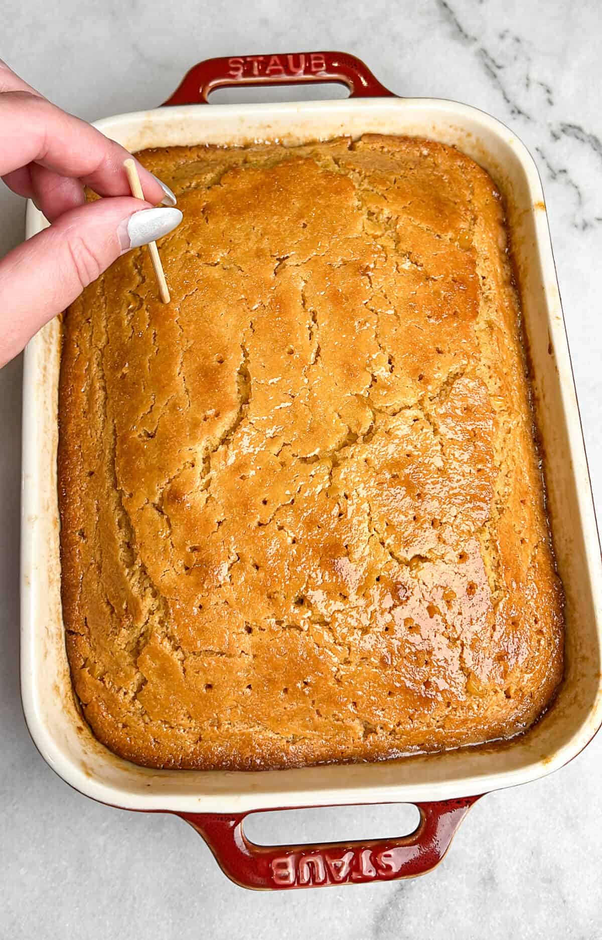 poking holes in the top of the cornbread