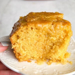 A big hunk of honey butter cornbread on a plate.