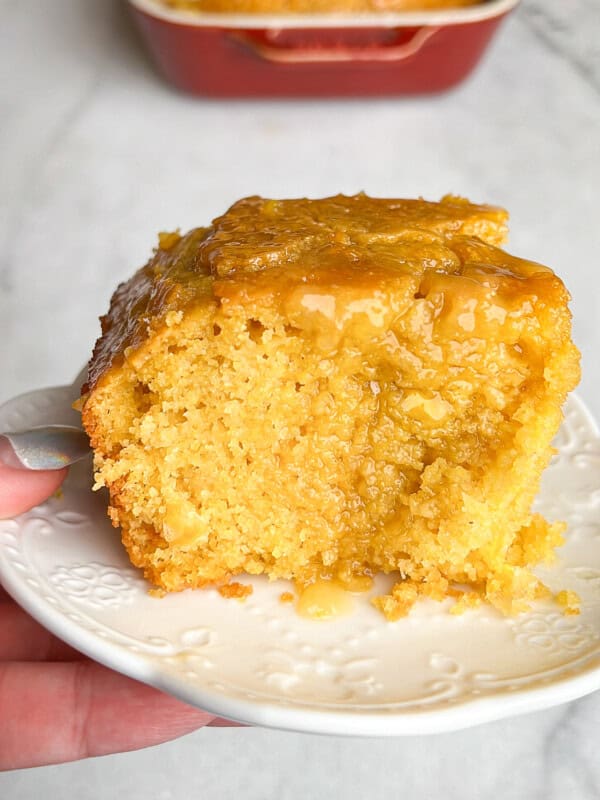 A big hunk of honey butter cornbread on a plate.