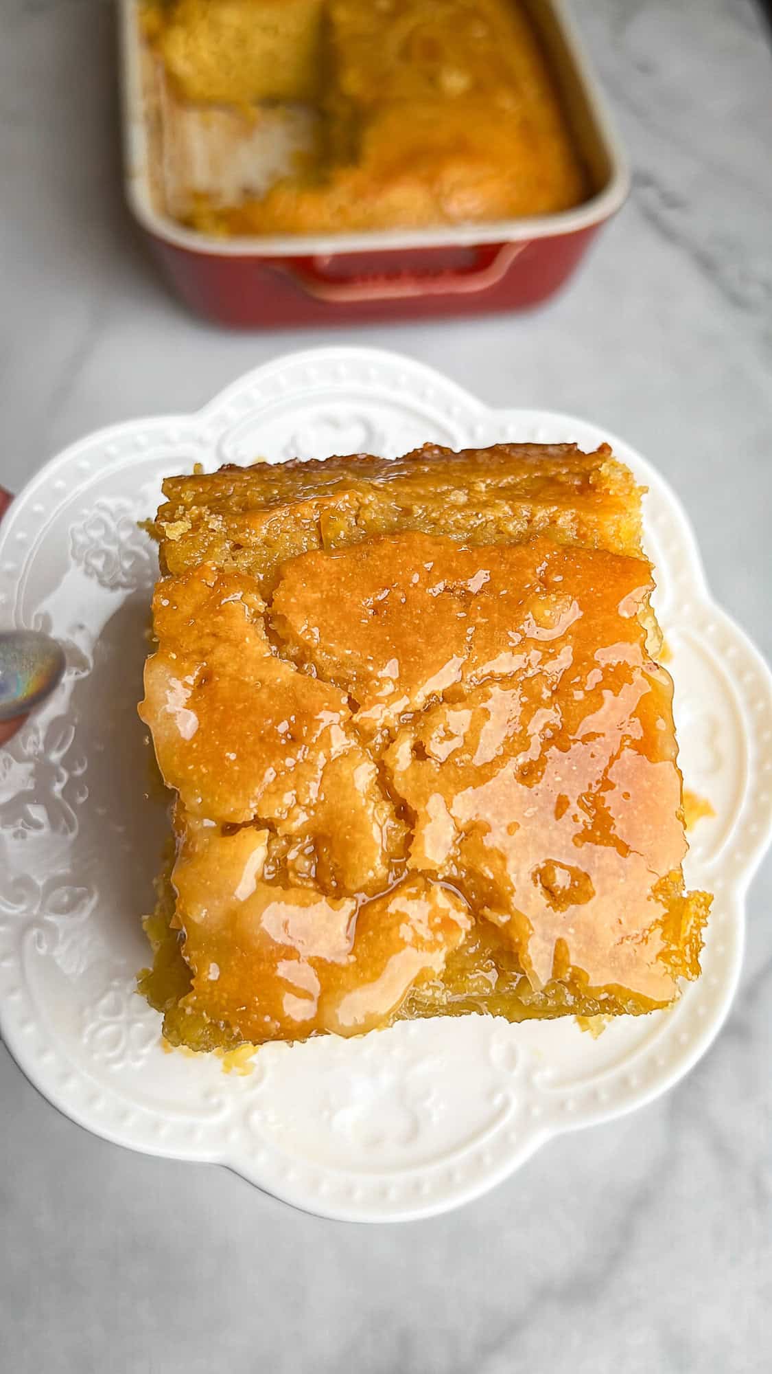 a slice of cornbread on a plate, glazed in honey butter