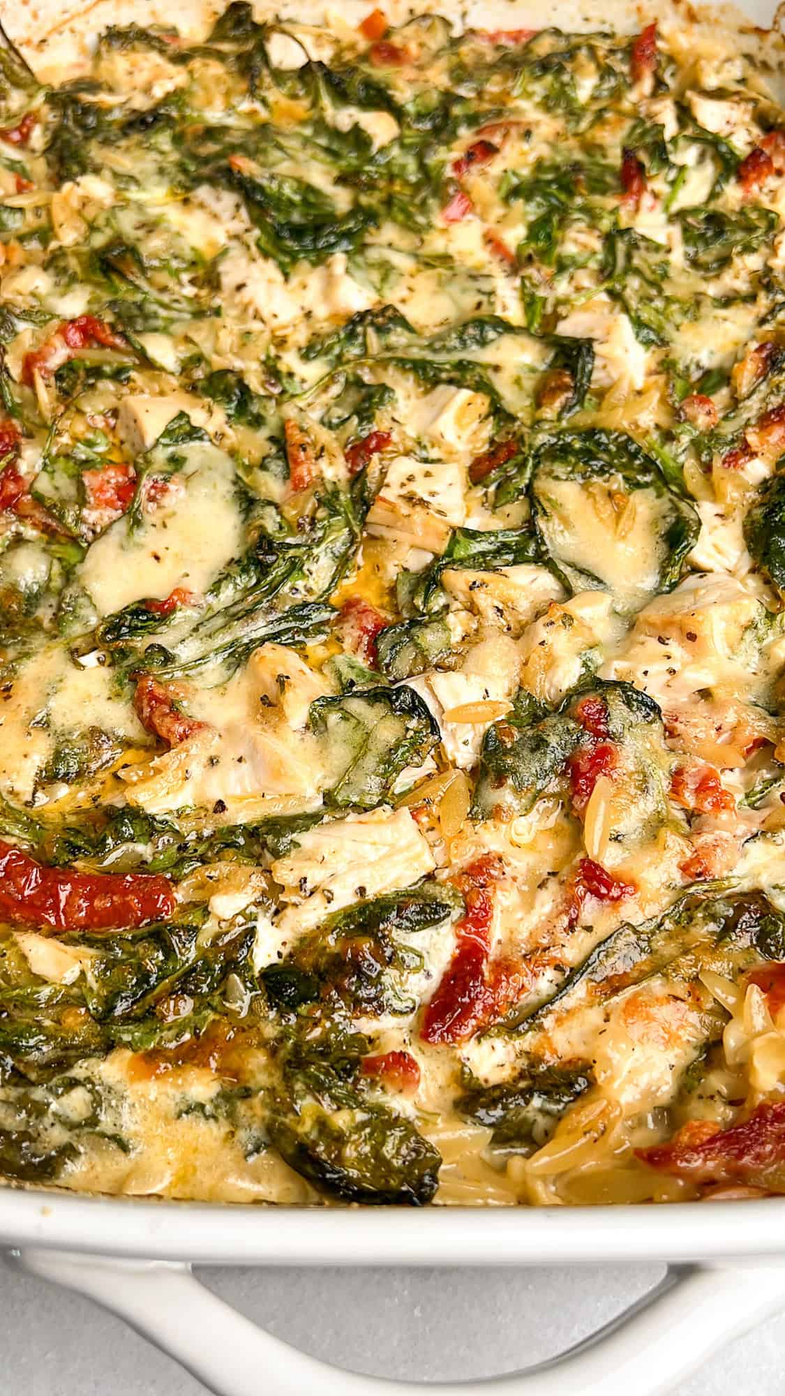 chicken orzo with spinach and basil in a pan out of the oven