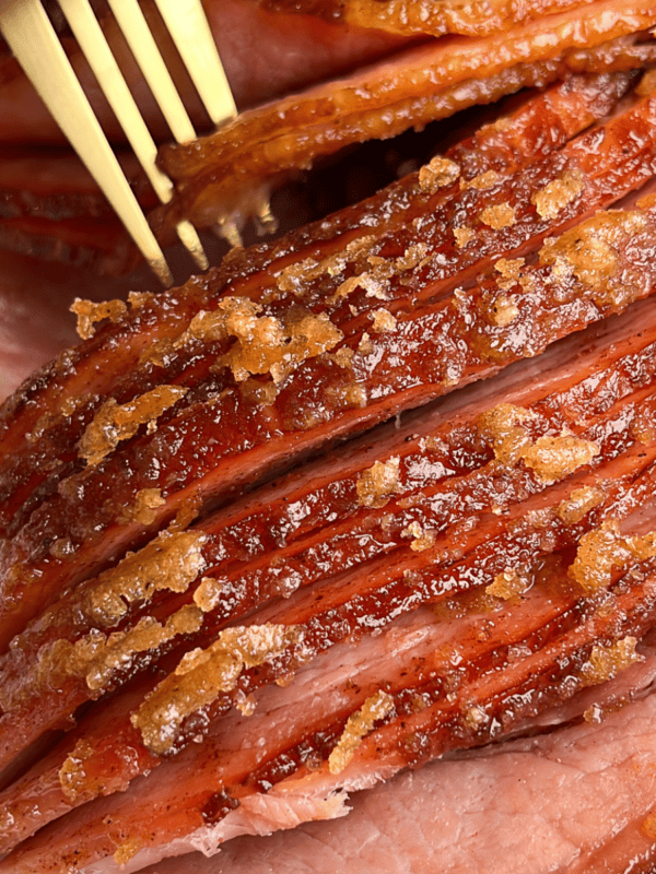 sliced ham being grabbed by a fork