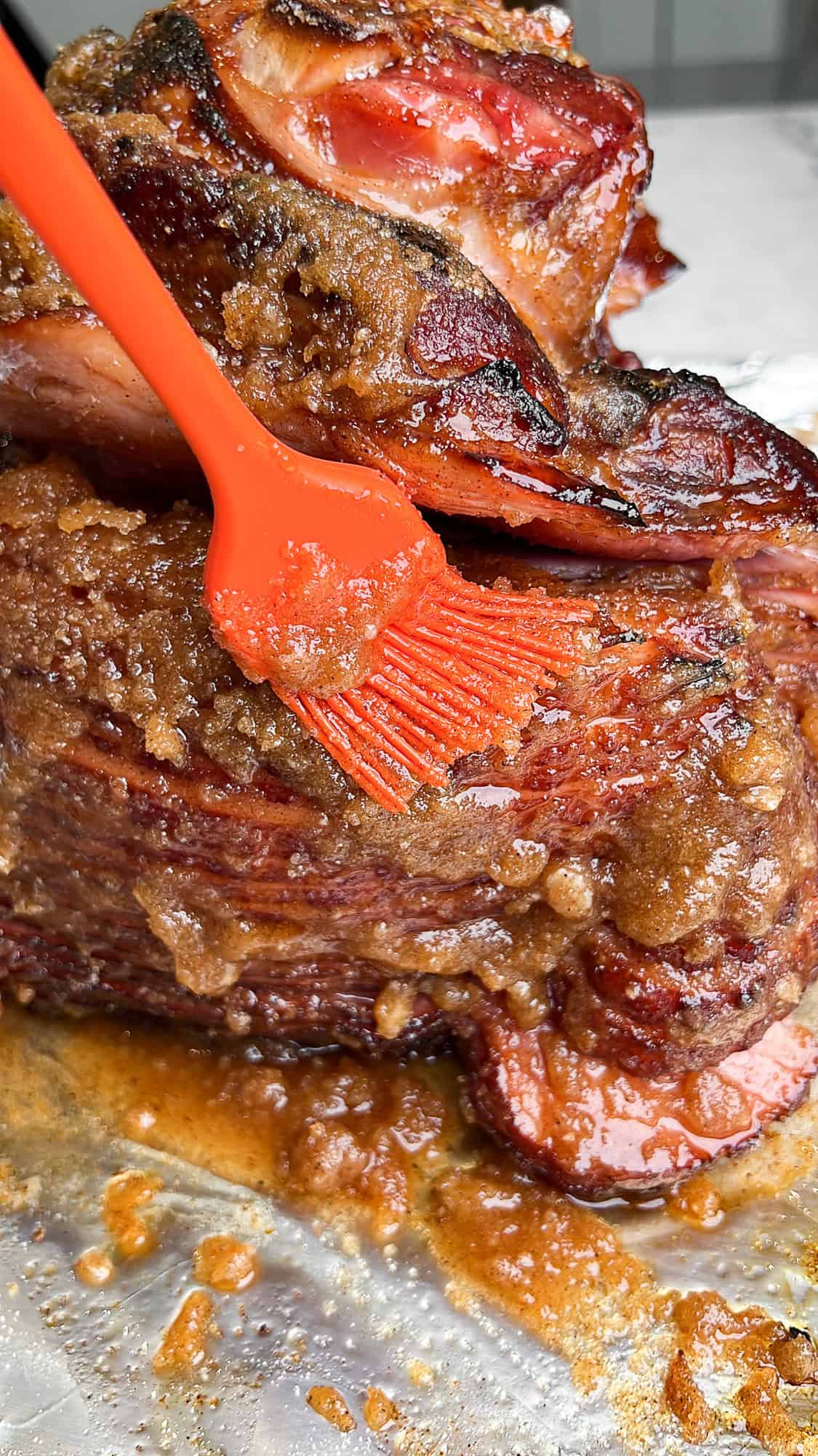 rubbing in the sugar coating glaze on the ham with a basting brush