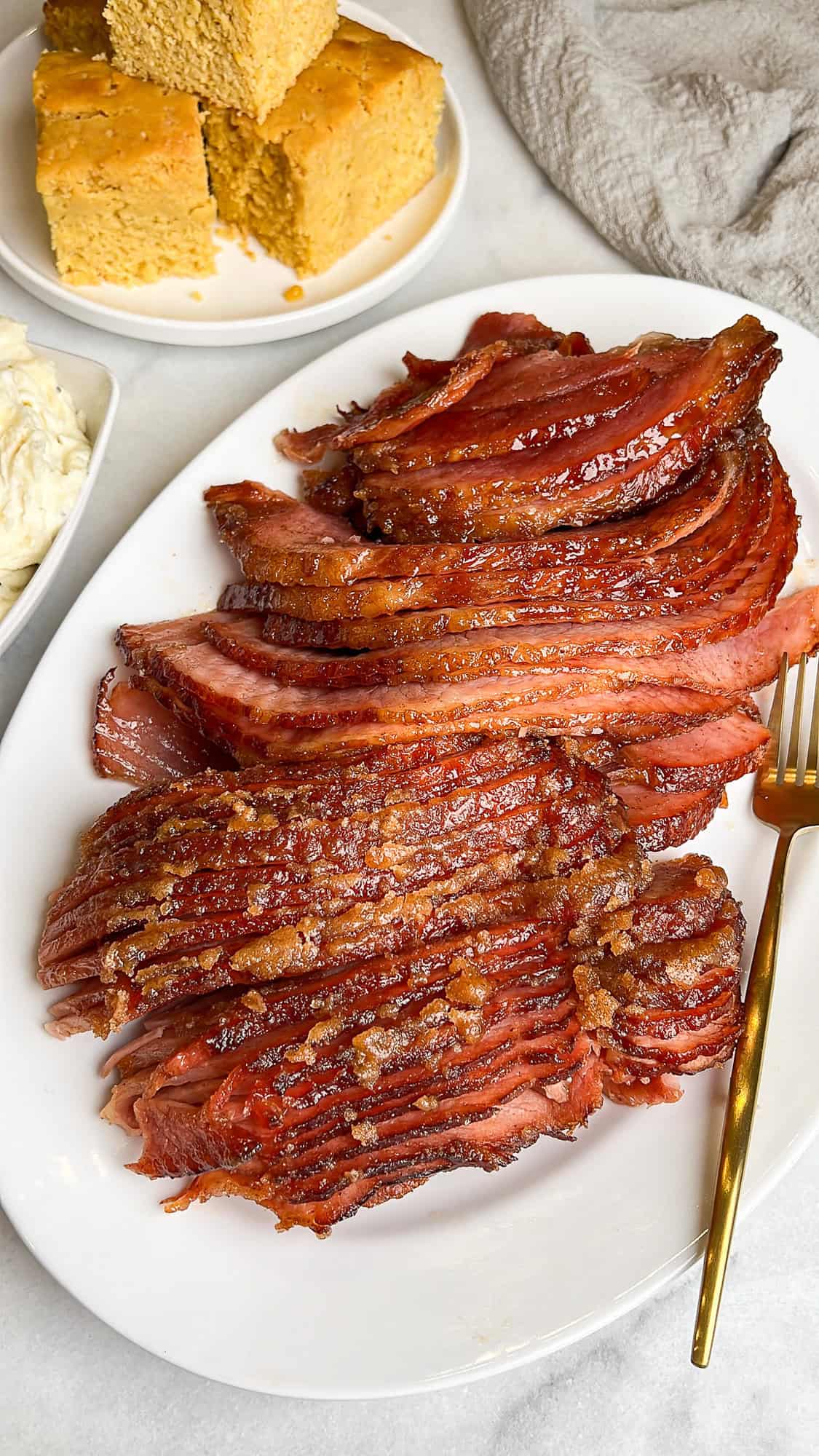 sliced ham on a serving platter on a thanksgiving table