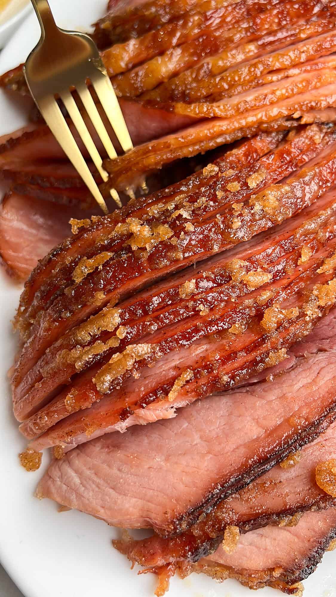 slow cooker ham with a candy crust sitting on a plate