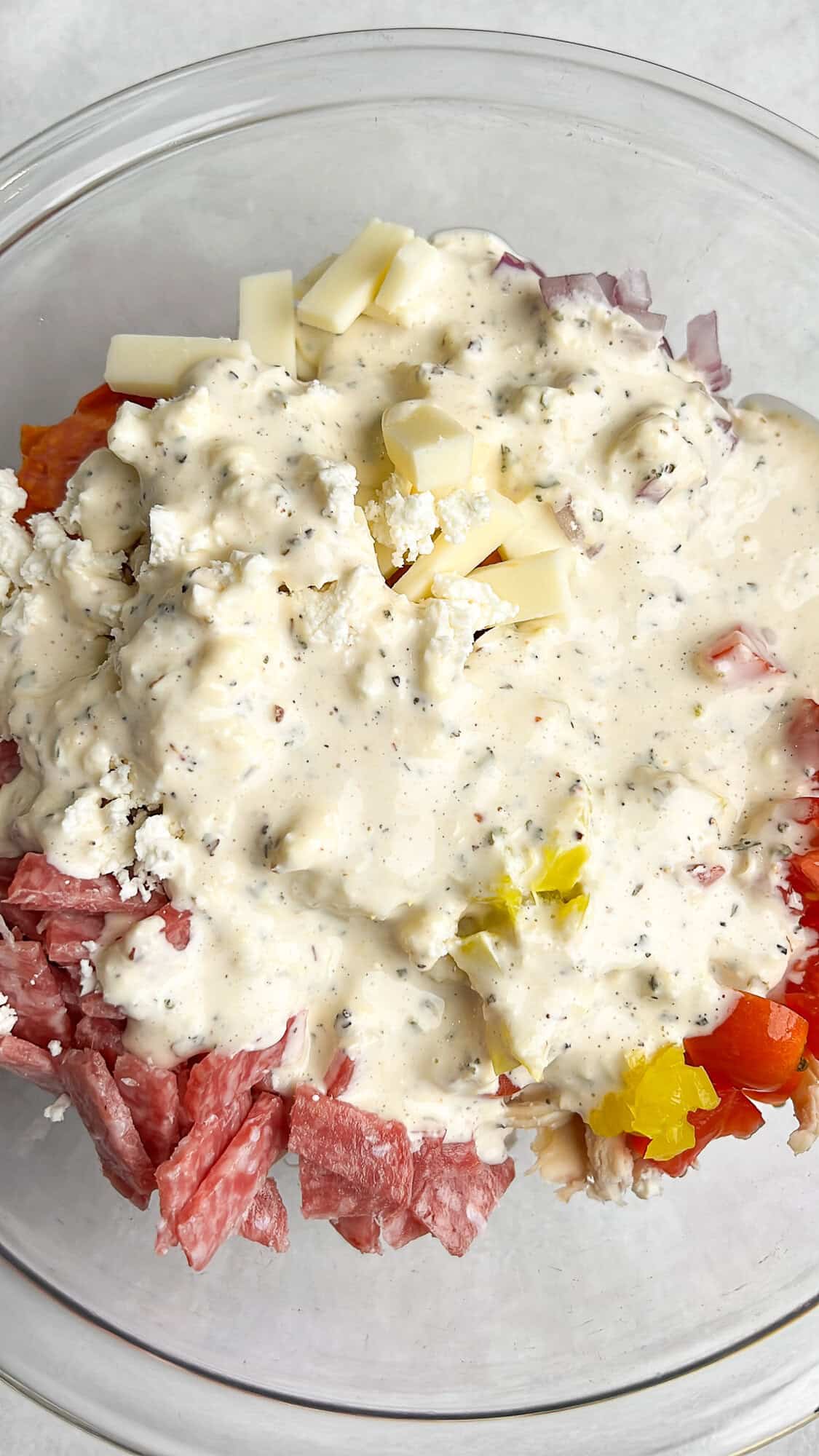 chicken salad in a bowl with dressing sitting on top