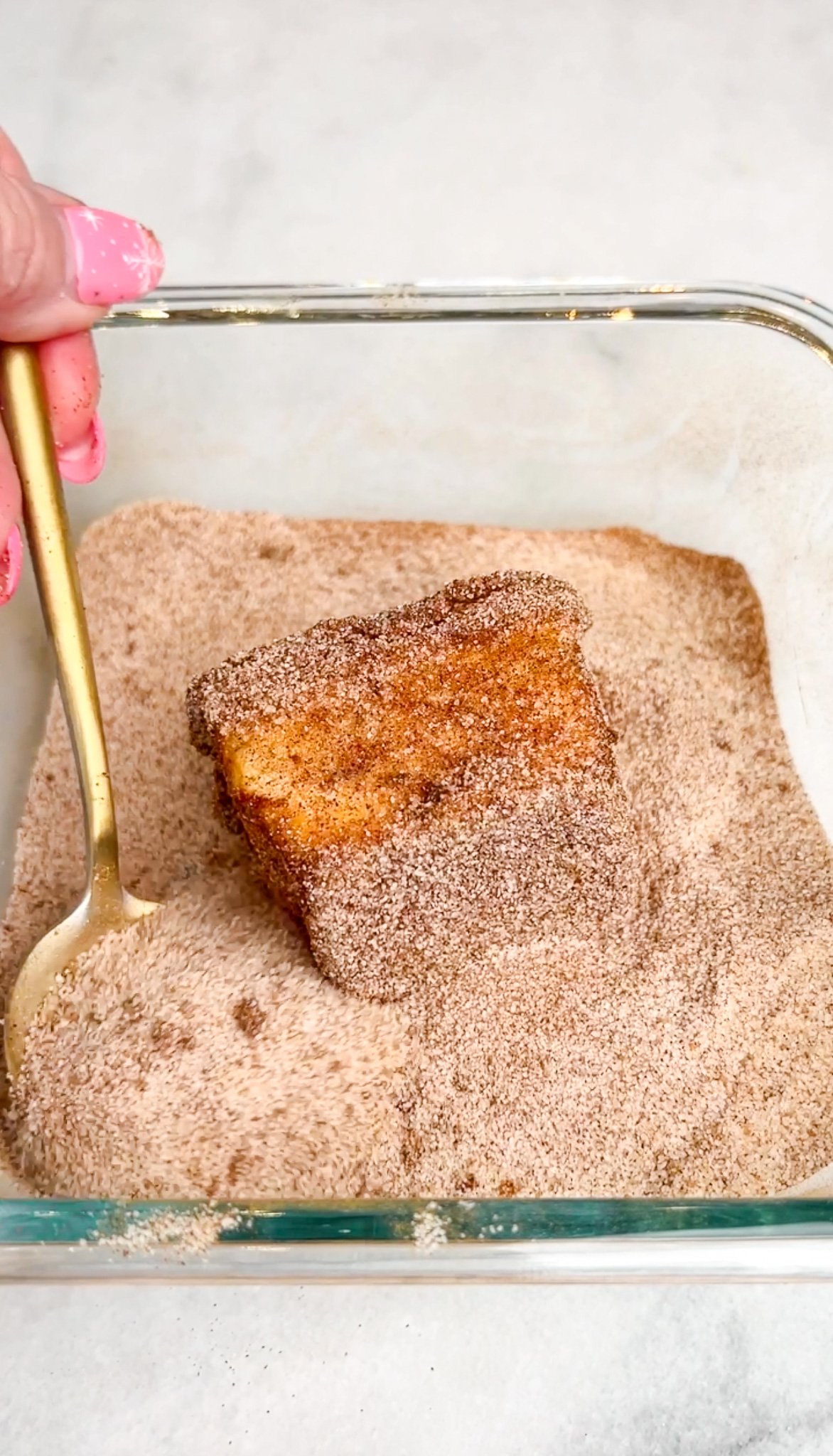 hawaiian roll french toast being tossed in cinnamon sugar