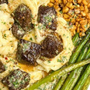 dinner plate with potatoes, steak, asparagus and corn drizzled with cowboy butter