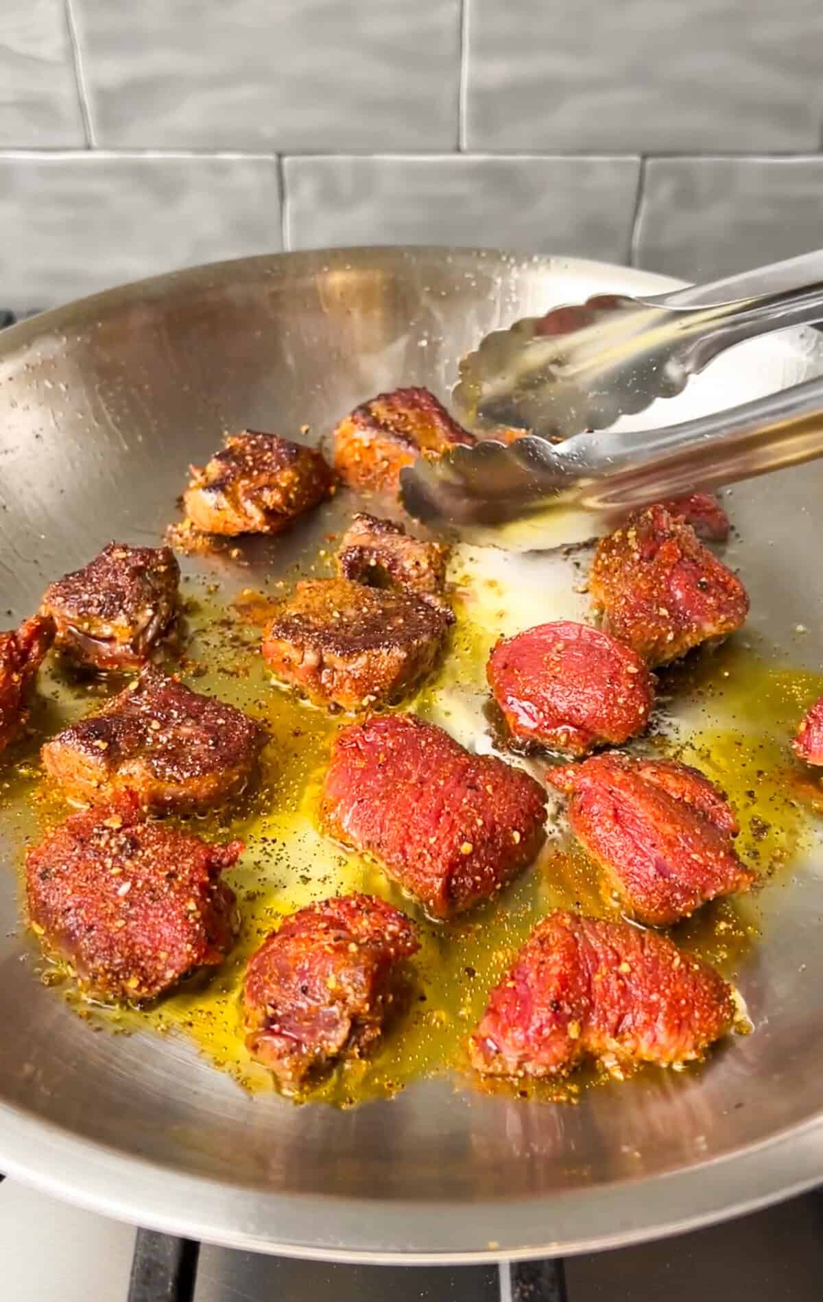 steak bites cooking on a pan