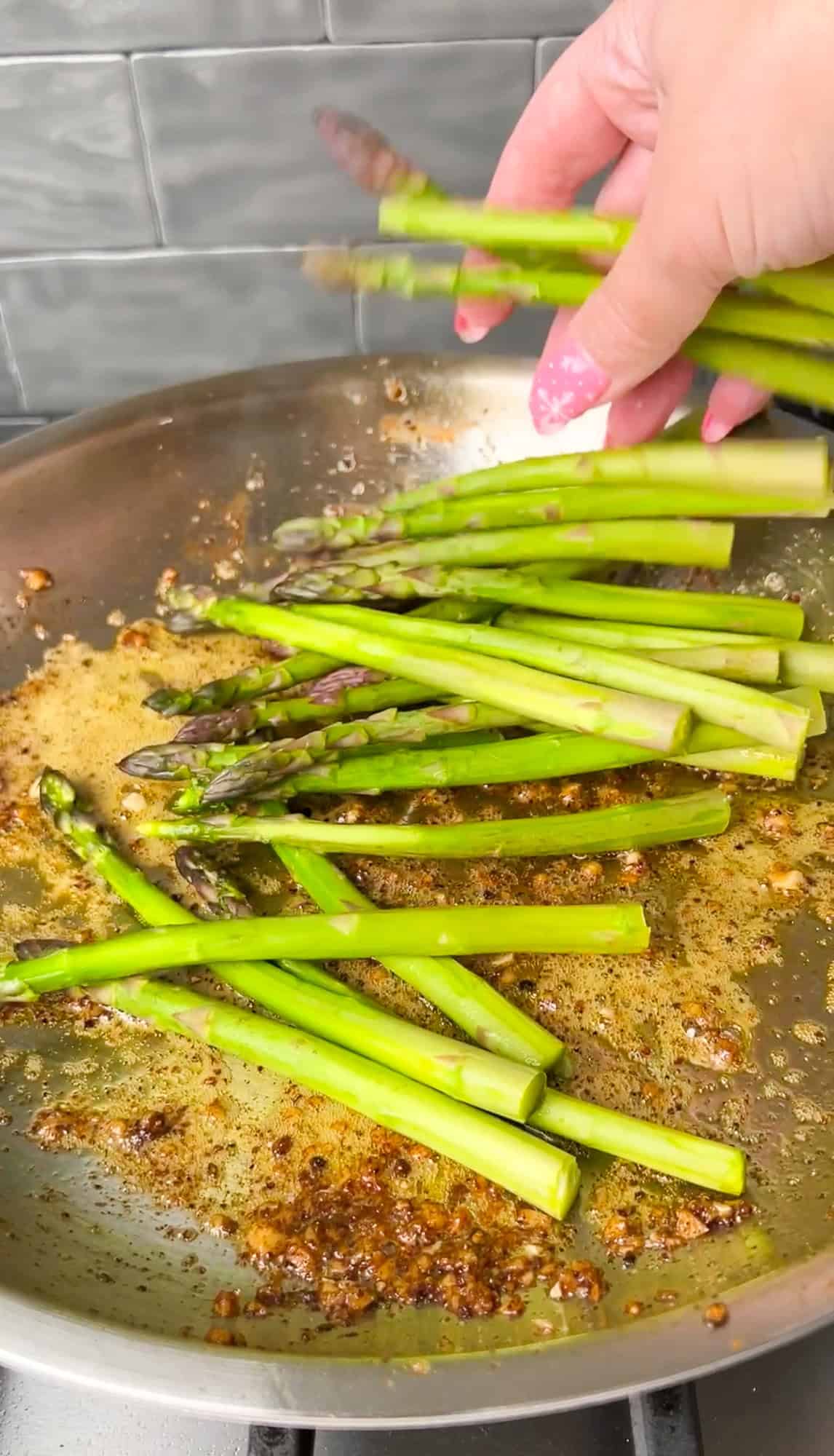 asparagus going into a buttered pan