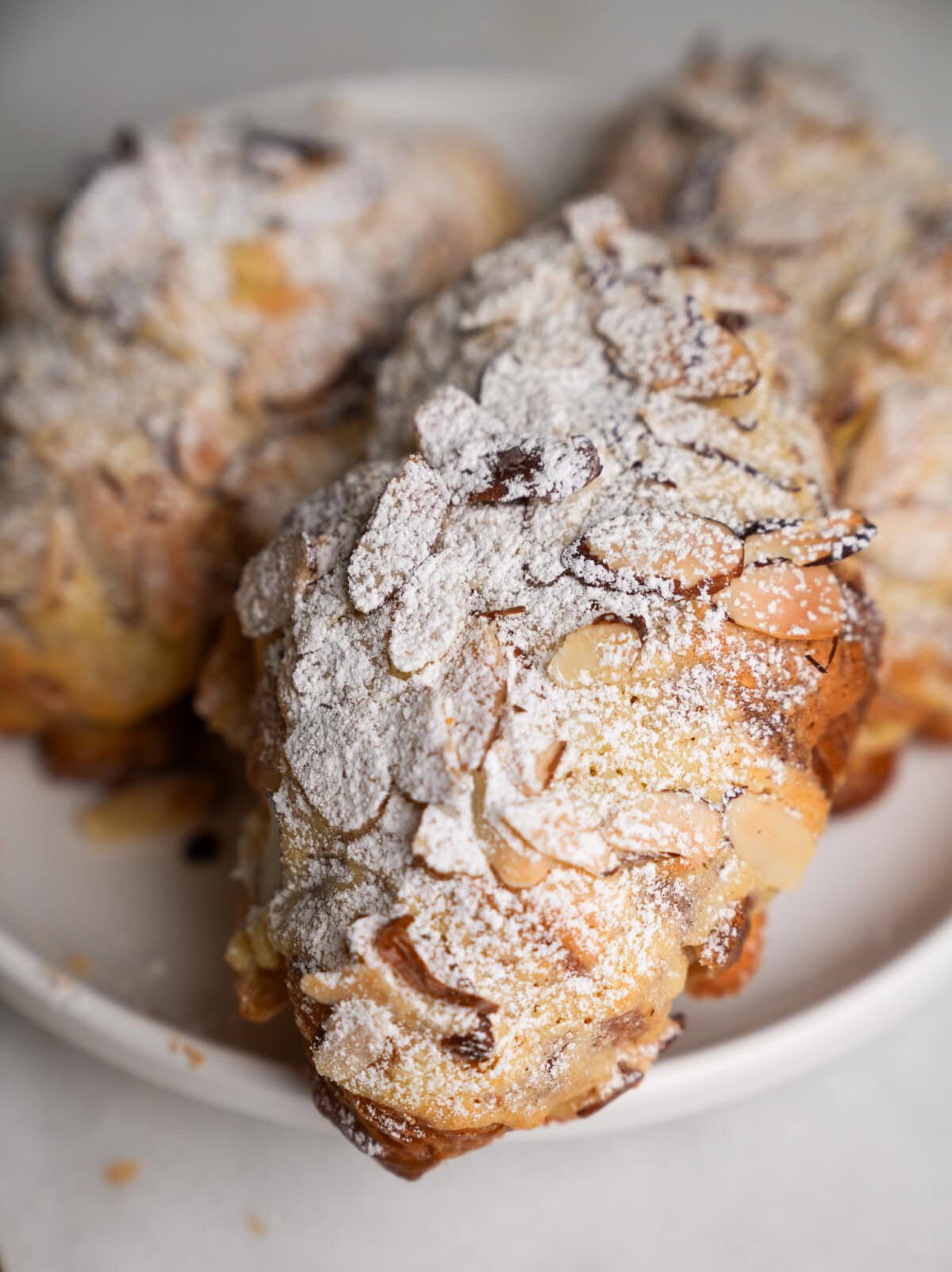 croissants dusted with powdered sugar sitting on a plate