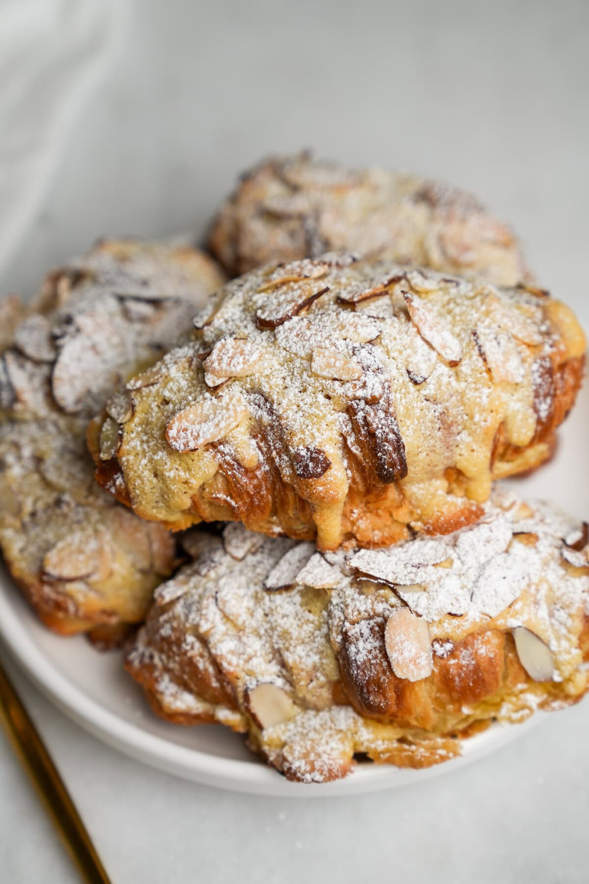 almond croissants stacked on a plate