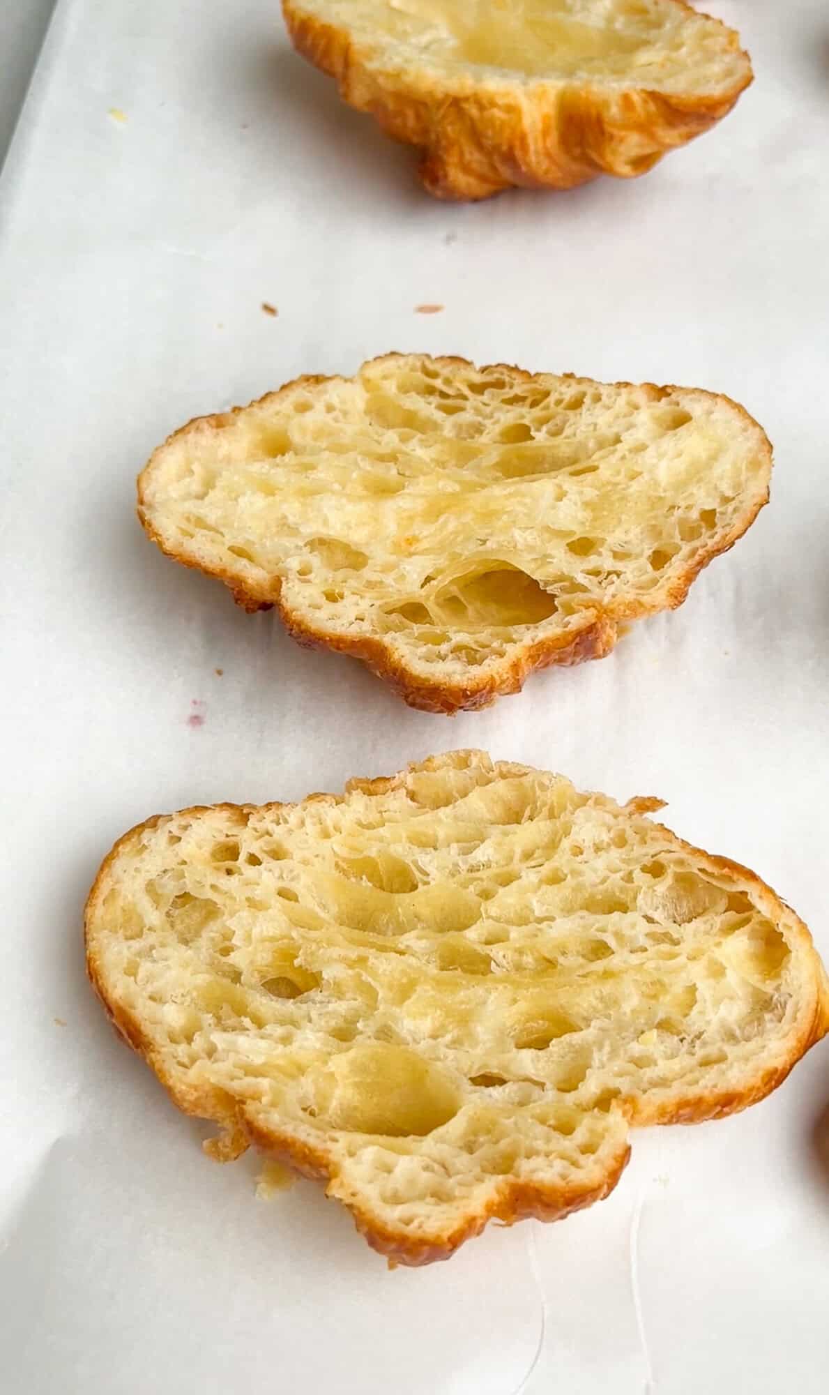 croissants sliced in half on a pan