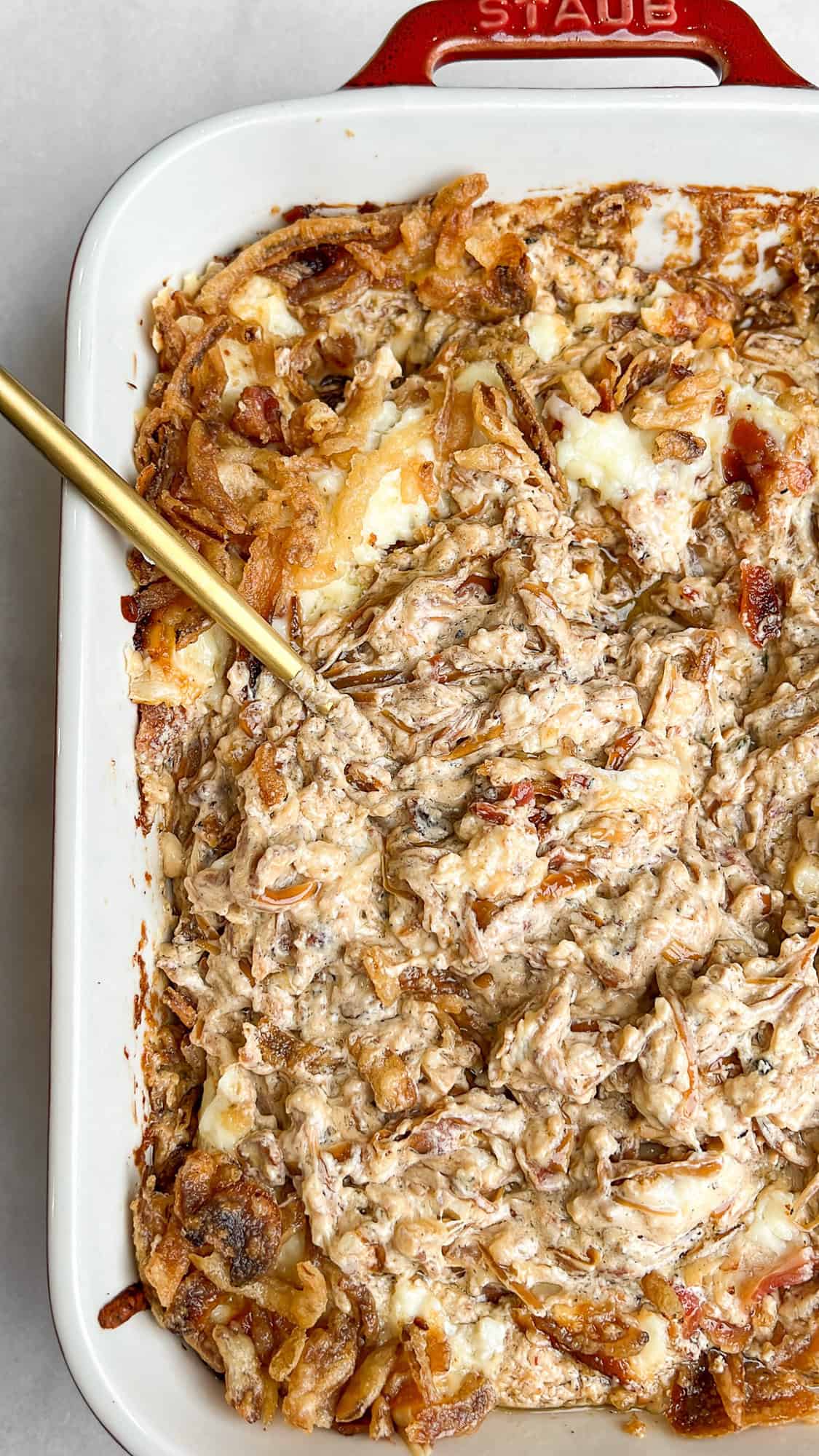 caramelized onion dip with bacon and melted cheese in a pan