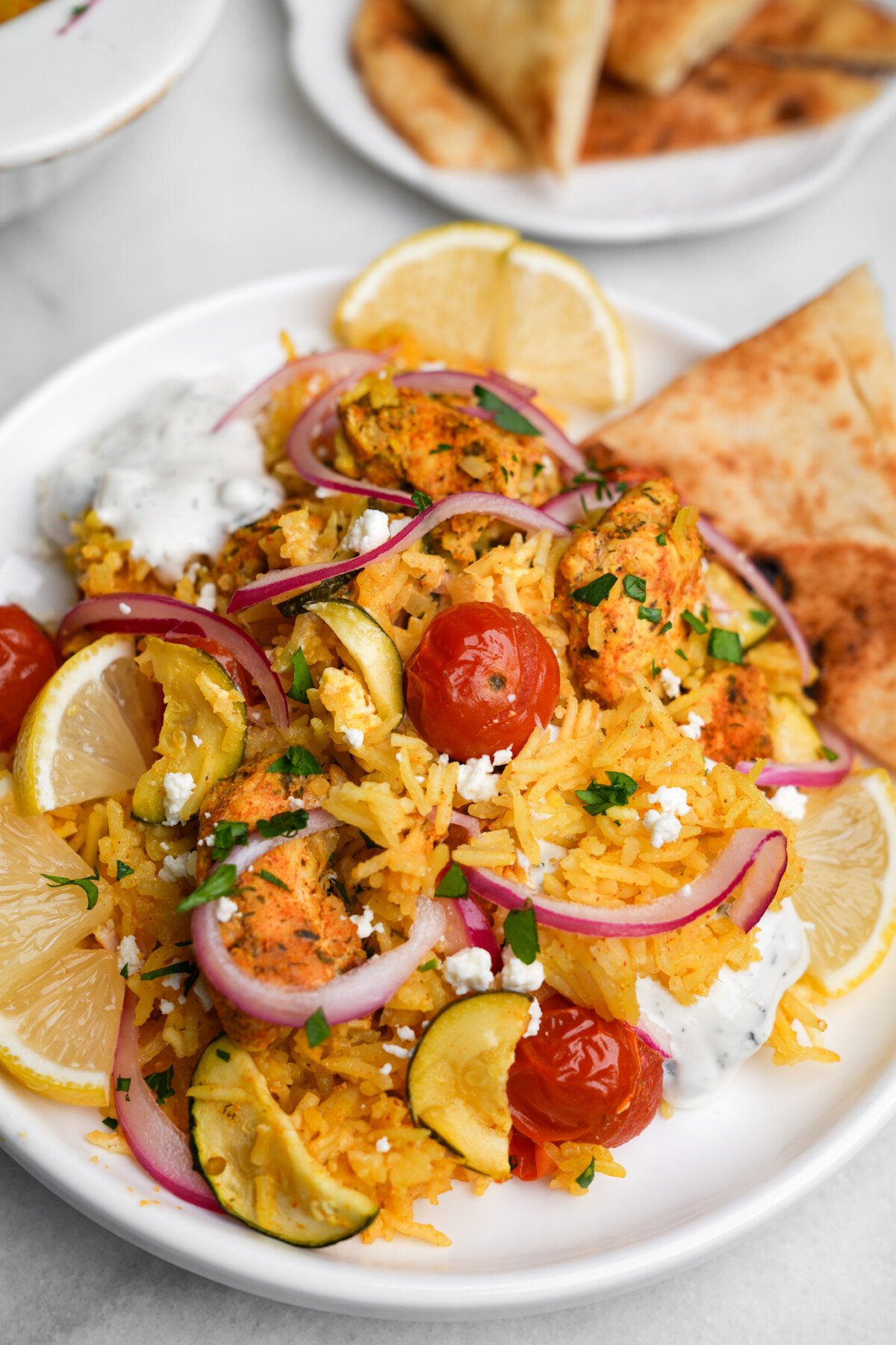 chicken tzatziki casserole portioned on a plate with pita bread